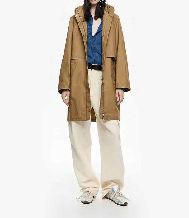 אישה לובשת מעיל חום אופנתי, חולצה כחולה ומכנסיים רחבים בגוון שמנת, צילום ל-CHOZEN