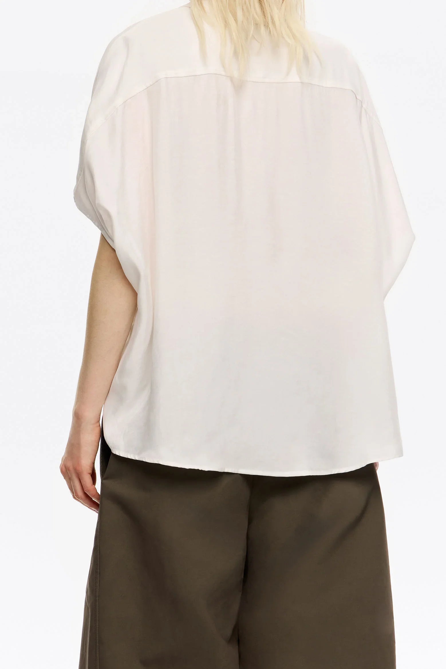 חולצה לבנה קצרה מבד קליל ואוורירי, על דוגמנית עם מכנסיים כהים, CHOZEN אופנה