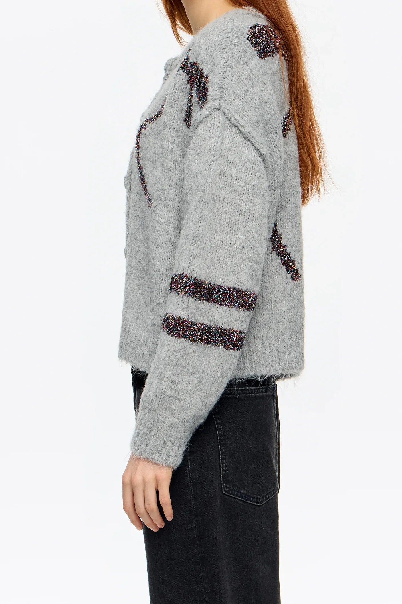 דוגמנית עם סוודר אפור עם דוגמאות צבעוניות ומכנסי ג'ינס כהים, אופנה CHOZEN