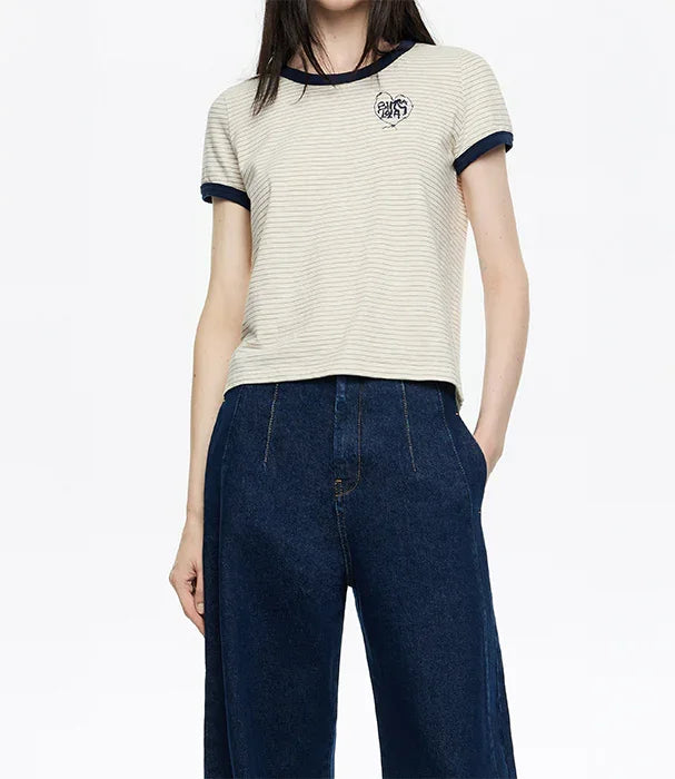 אישה לובשת חולצת פסים קצרה עם סמל ושרוולים כחולים ומכנסי ג'ינס, אופנה CHOZEN