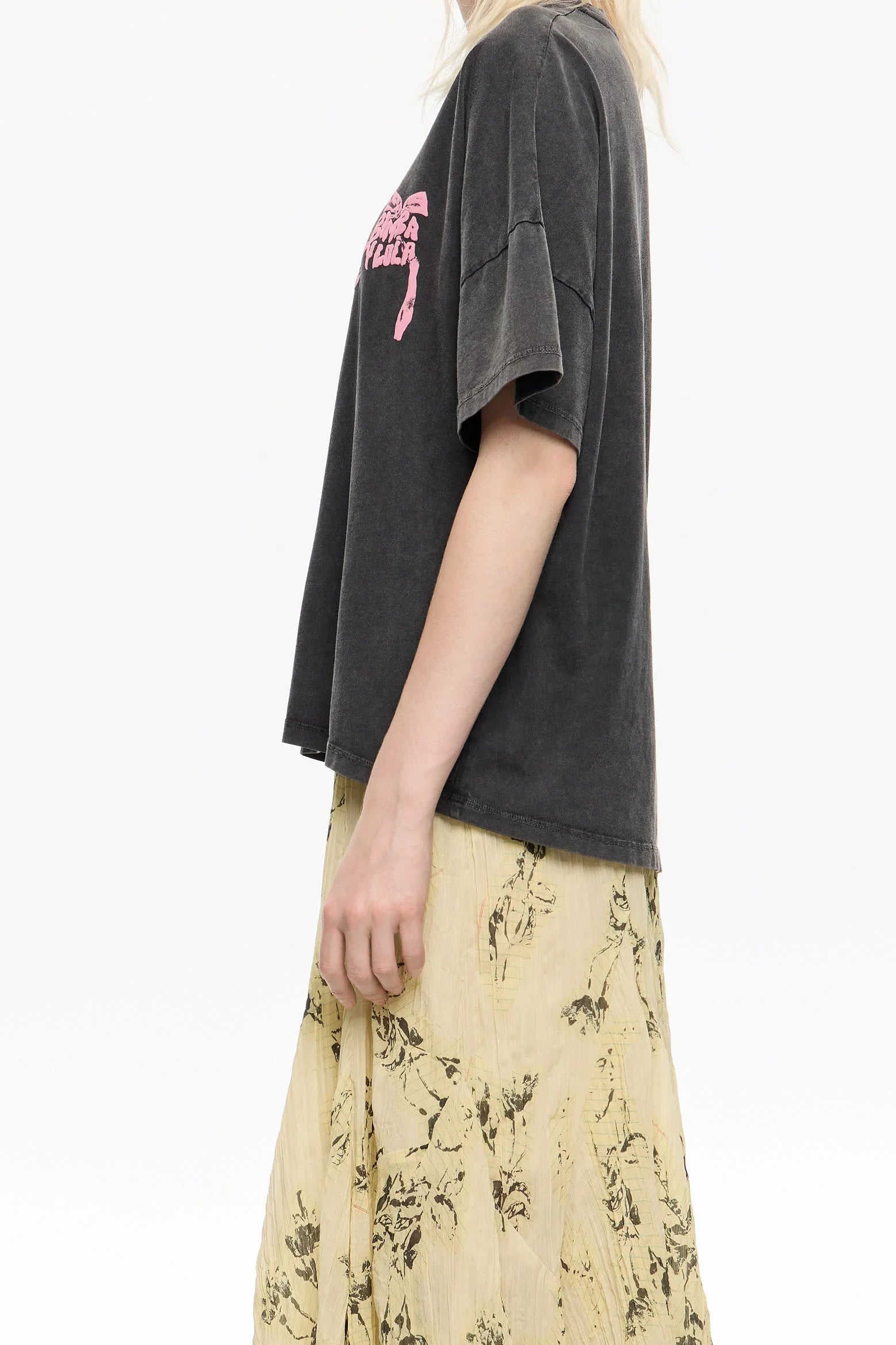 אישה עם חולצת טי אפורה עם הדפס ורוד וחצאית צהובה פרחונית, אופנה טרנדית CHOZEN