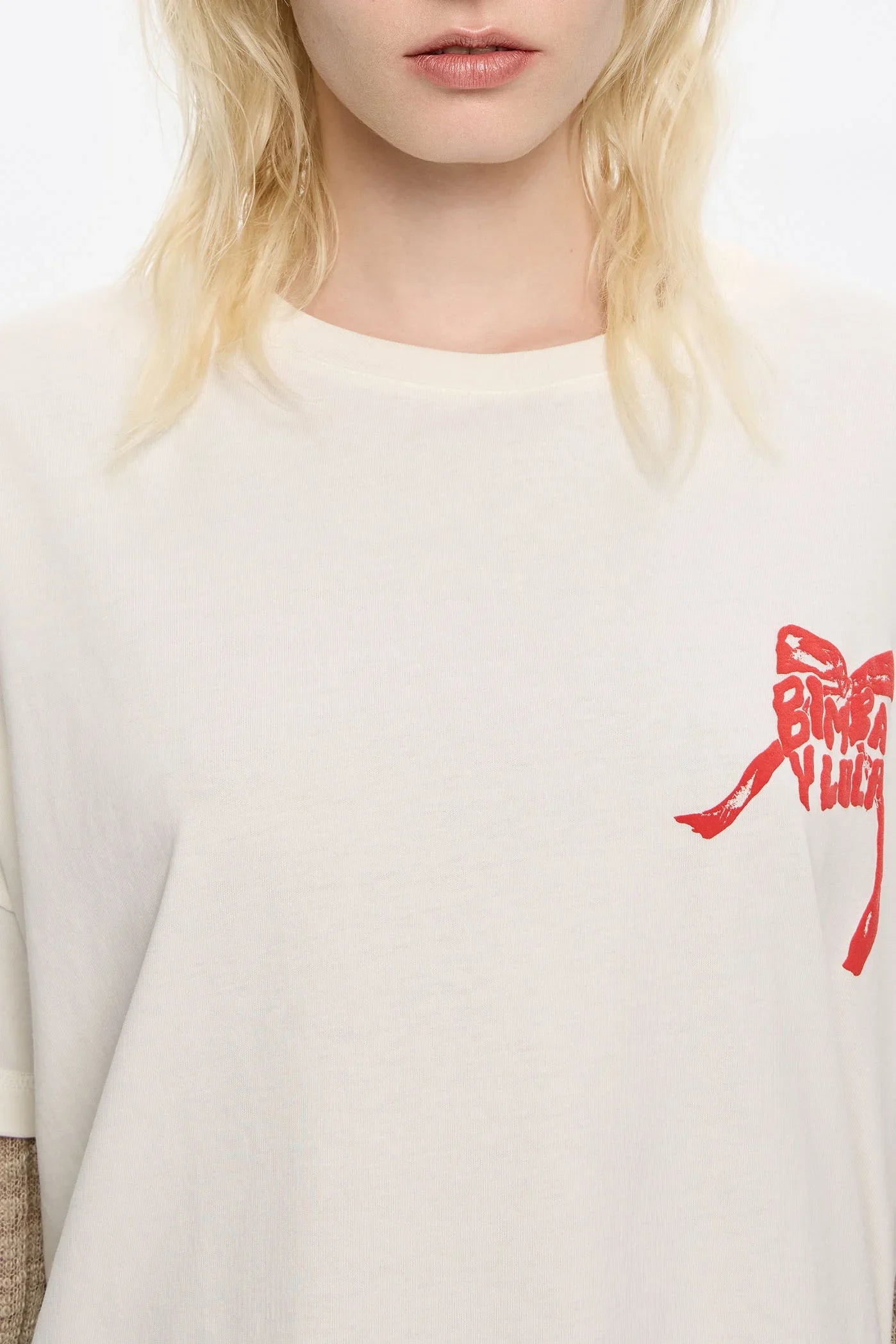 חולצת טי שרט לבנה עם הדפס סרט אדום וכיתוב BIMBA Y LOLA, מבית CHOZEN מותגים מובילים