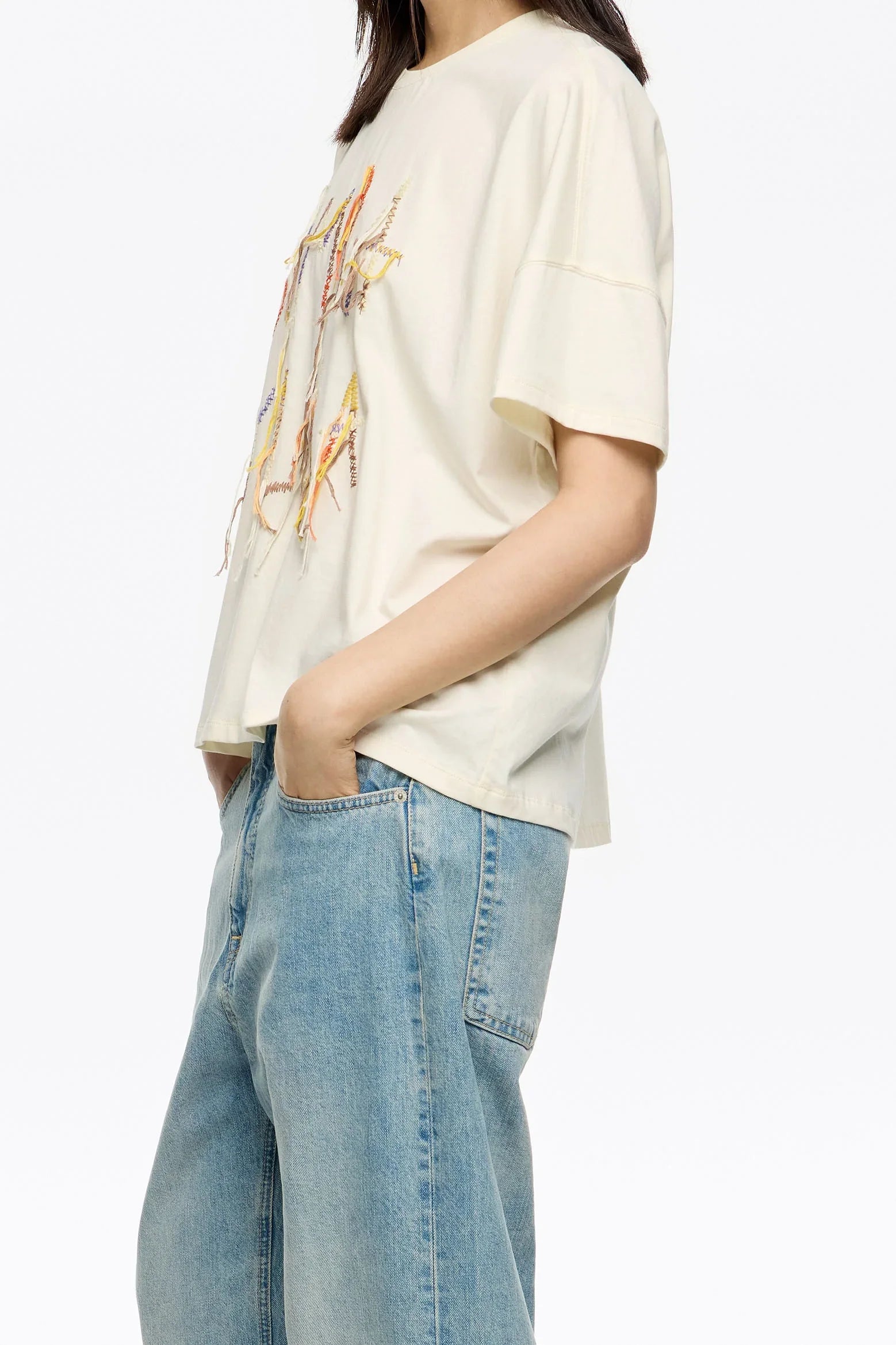 חולצת טי שירט לבנה לנשים עם הדפס צבעוני, בשילוב ג'ינס בגזרה רחבה, מעוצבת אופנתית מבית CHOZEN