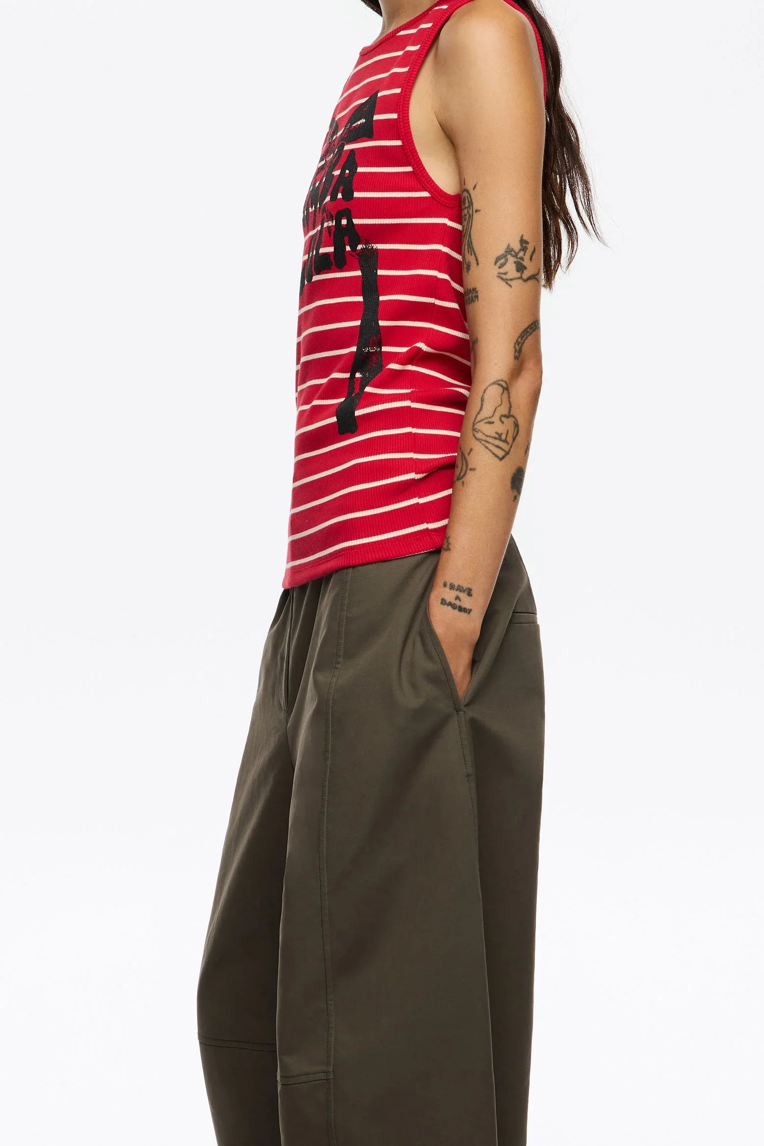 דוגמנית עם גופיית פסים אדומה ומכנסיים ירוקים, אופנת CHOZEN, קעקועים בולטים על הזרוע