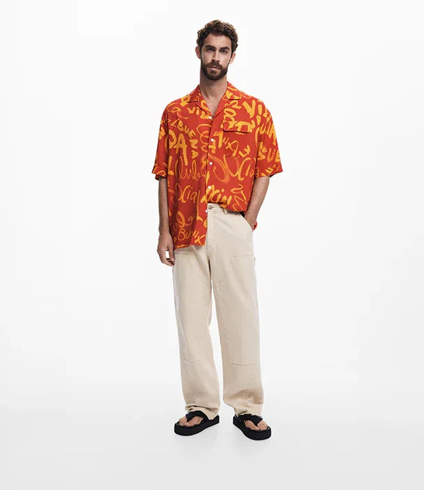 גבר לובש חולצה כתומה עם הדפס גרפי ומכנסיים בהירים, אופנת קיץ CHOZEN