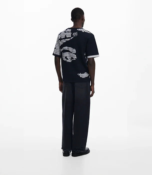 גבר לובש חולצת טי כהה עם הדפסים לבנים, מכנסיים רחבים, אופנה עדכנית CHOZEN