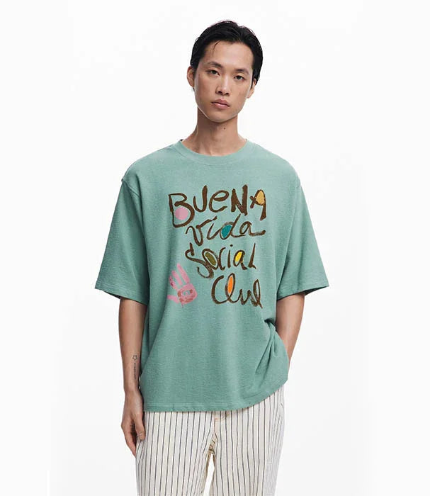 גבר לובש טי שירט ירוקה עם כיתוב 'BUENA VIDA SOCIAL CLUB', אופנה עכשווית CHOZEN