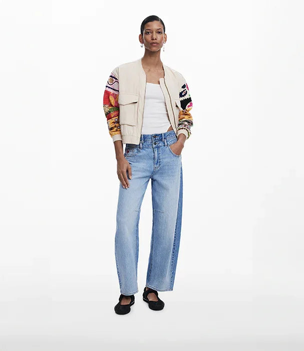 אופנת CHOZEN: דוגמנית לובשת ג'ינס בגזרה ישרה, גופייה לבנה וז'קט עם שרוולים צבעוניים