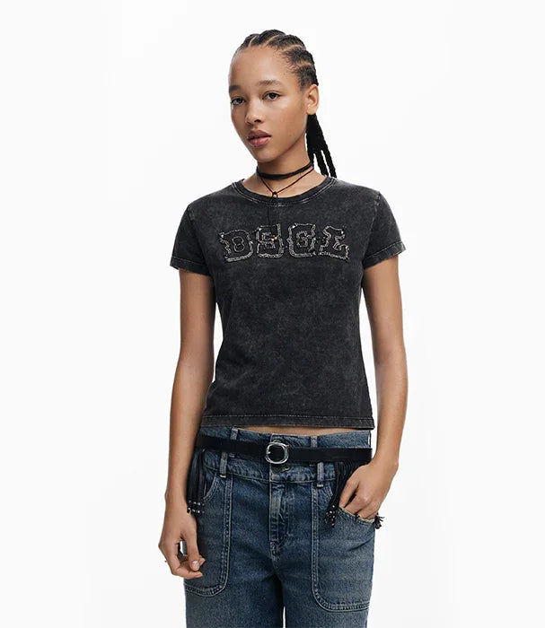 אישה צעירה לובשת טי שרט שחורה עם כיתוב, ג'ינס ואקססוריז, אופנה מודרנית CHOZEN