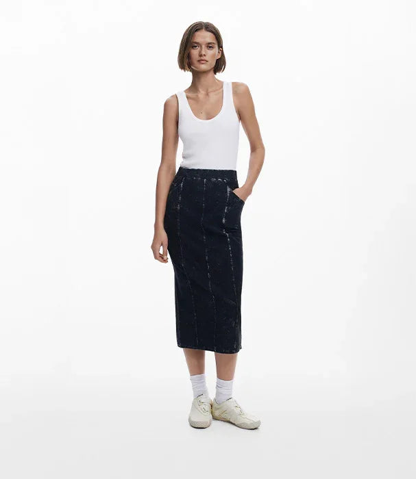 דוגמנית לובשת חצאית ג'ינס כהה וחולצת גופיה לבנה, צילום אופנה עם רקע לבן ל-CHOZEN