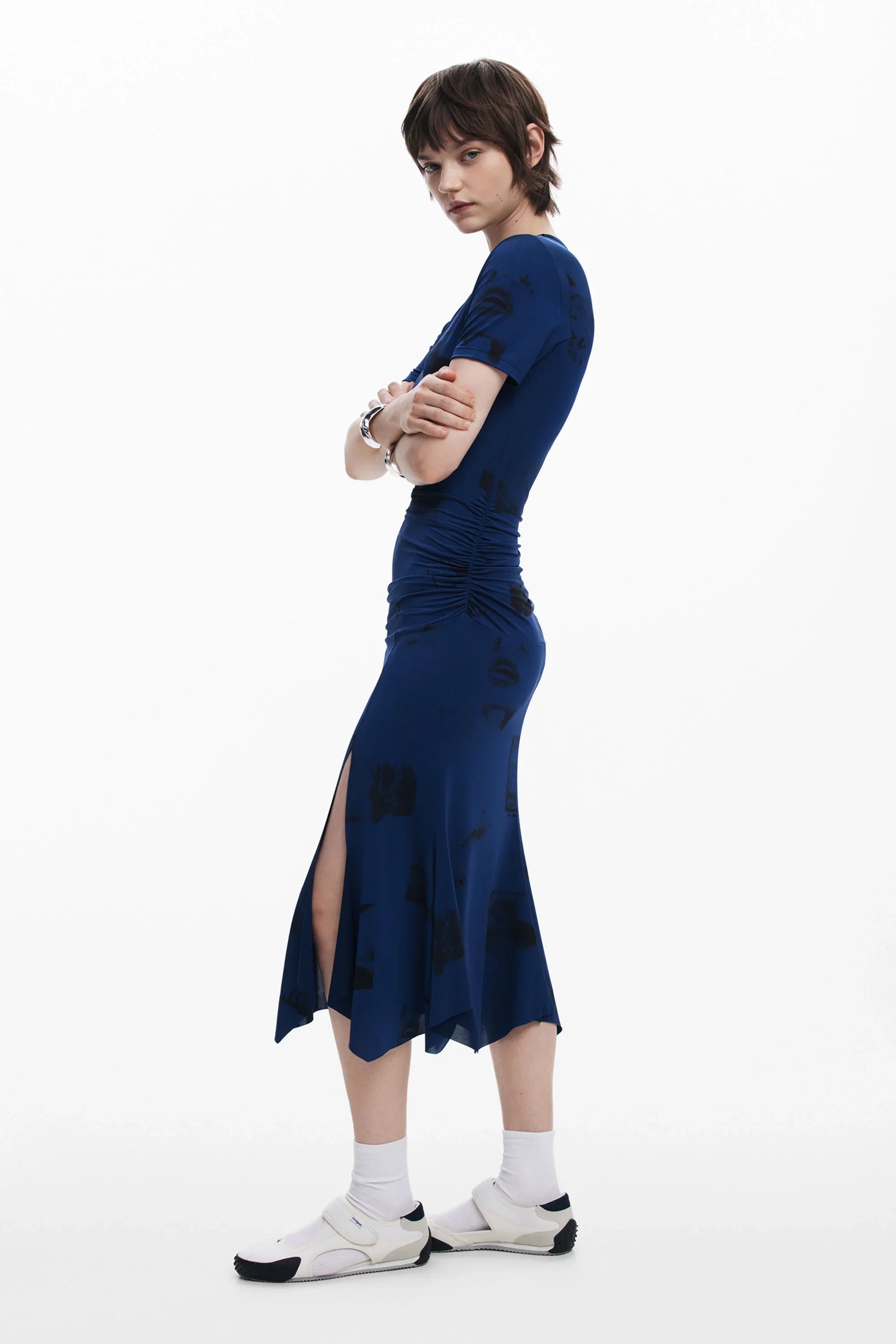 דוגמנית לובשת שמלת מקסי כחולה עם שרוולים קצרים וחריץ צד, על רקע לבן, חנות CHOZEN