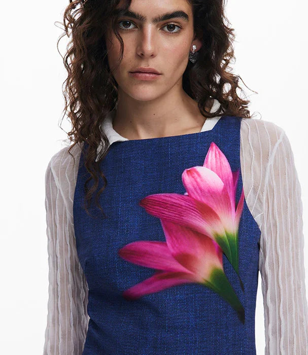 דוגמנית לובשת שמלה כחולה עם הדפס פרח ורוד בולט מבית CHOZEN מותגים מובילים