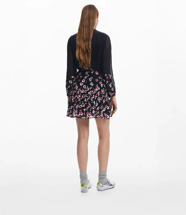 אישה עם שמלת מיני כהה בדוגמת פרחים, נעלי ספורט וגרביים אפורות, צילום גב, CHOZEN