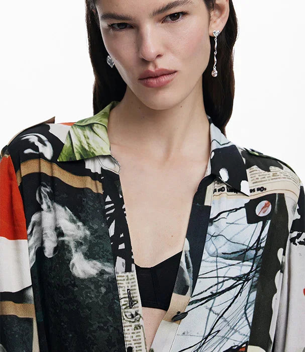 אישה לובשת חולצת משי מודפסת צבעונית של מותג אופנה מוביל ב-CHOZEN, עגילים נוצצים