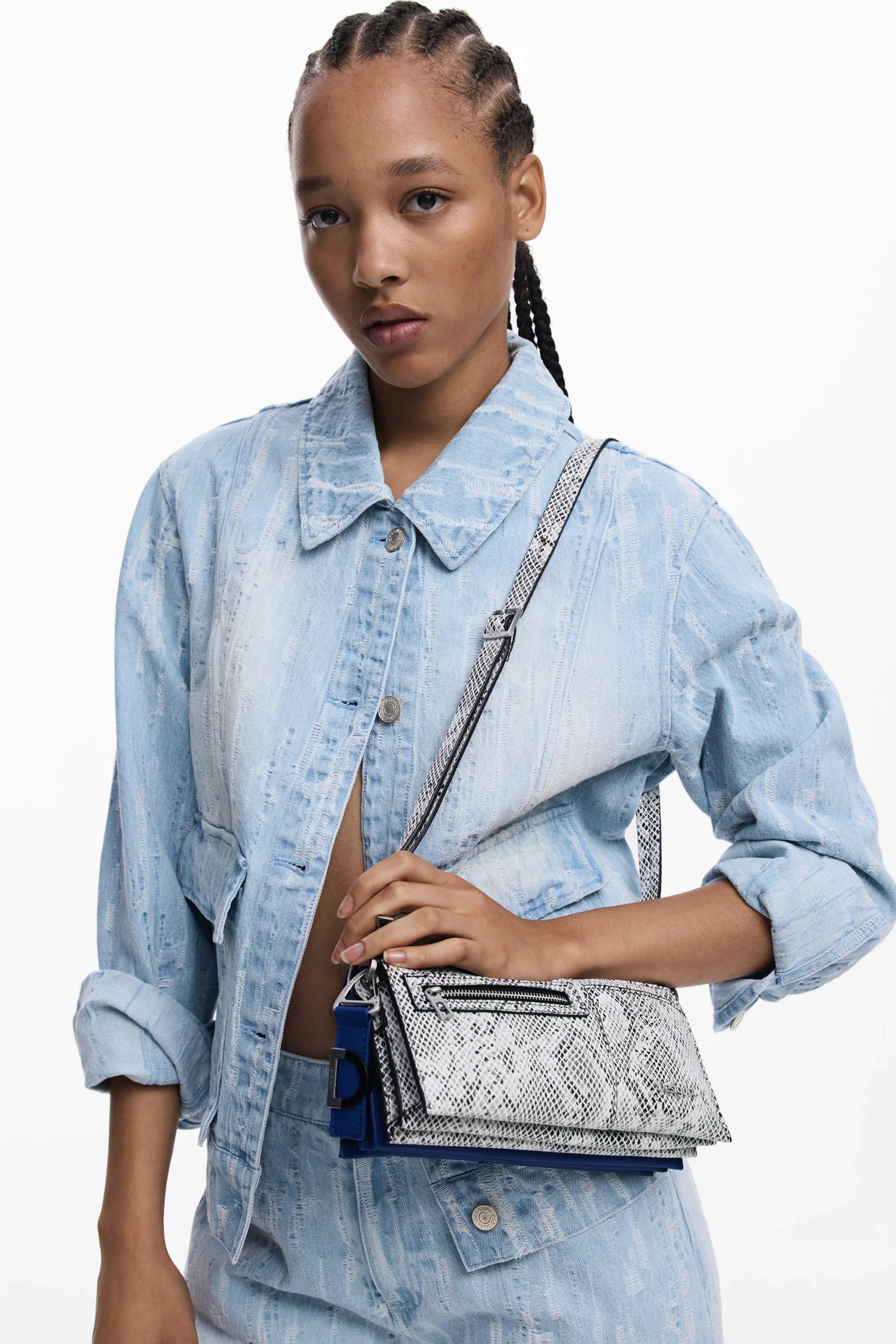 דוגמנית עם ג'קט וג'ינס דנים תכלת, מחזיקה תיק צד אופנתי, צילום אופנה CHOZEN