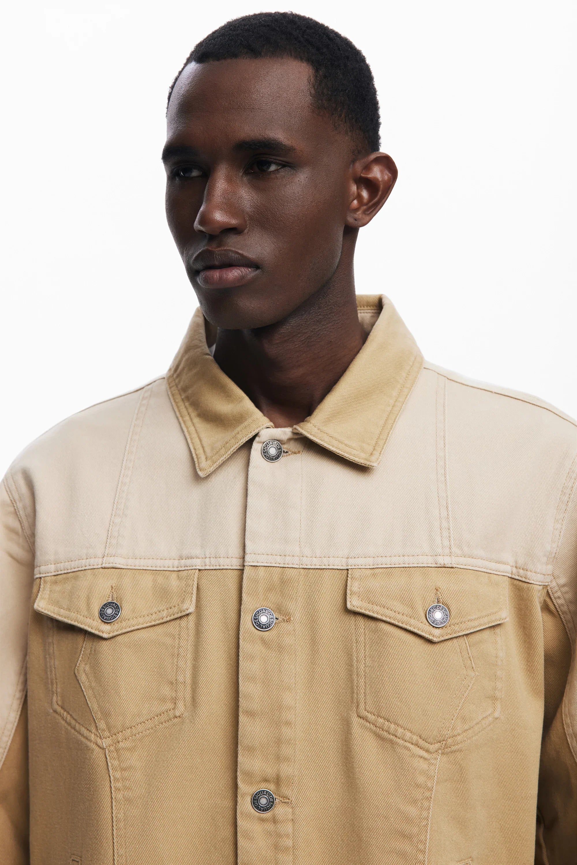 מודל לובש ג'קט ג'ינס בגוון בז' אופנתי מחנות CHOZEN, בגדי מותגים מקוריים