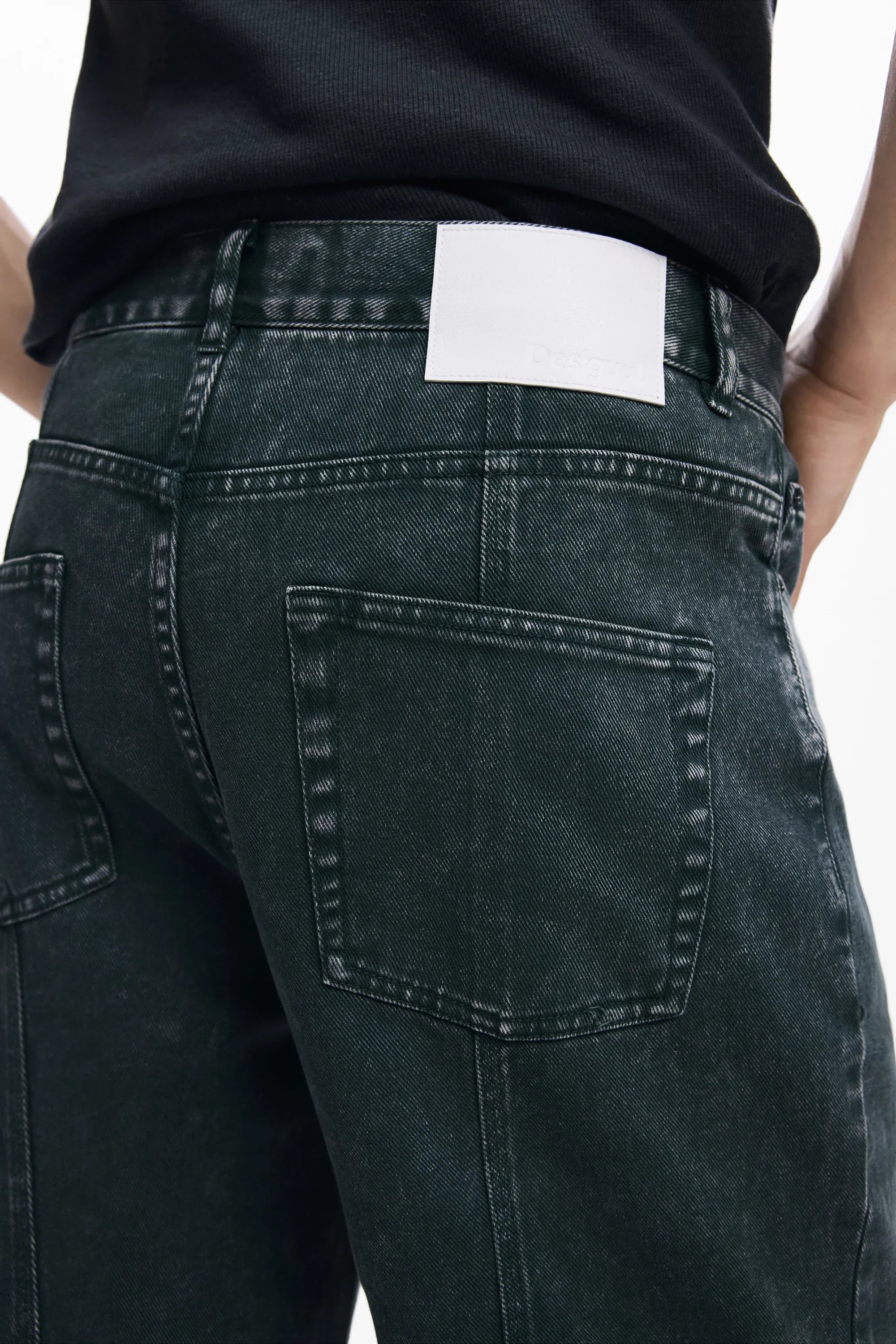 מבט מקרוב על ג'ינס כהה עם שני כיסים אחוריים ותווית לבנה, מבית CHOZEN