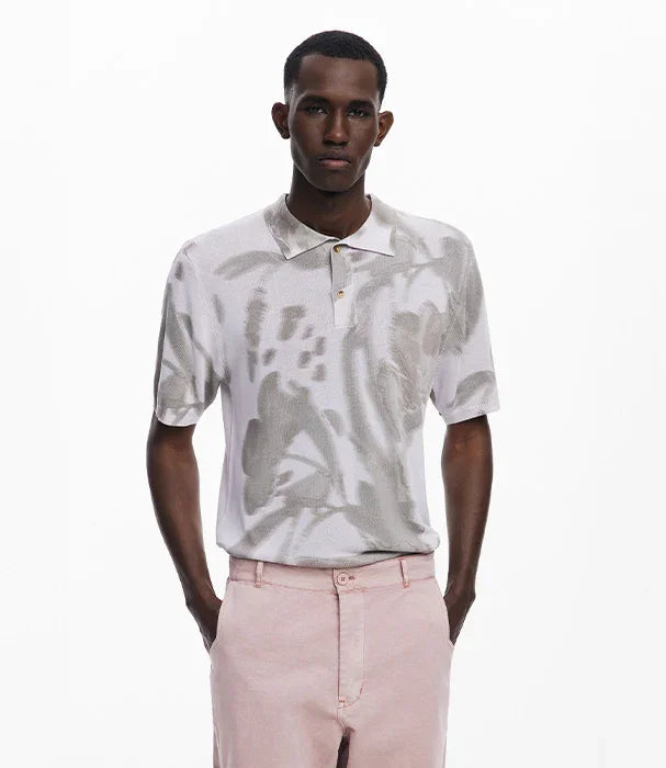 דוגמן לובש חולצת פולו עם דוגמה אמנותית מכופתרת ומכנסיים ורודים, אופנת CHOZEN