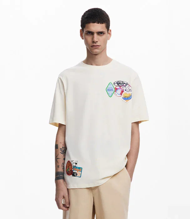 גבר לובש חולצת טי לבנה עם פאצ'ים צבעוניים, אופנת רחוב CHOZEN, רקע לבן