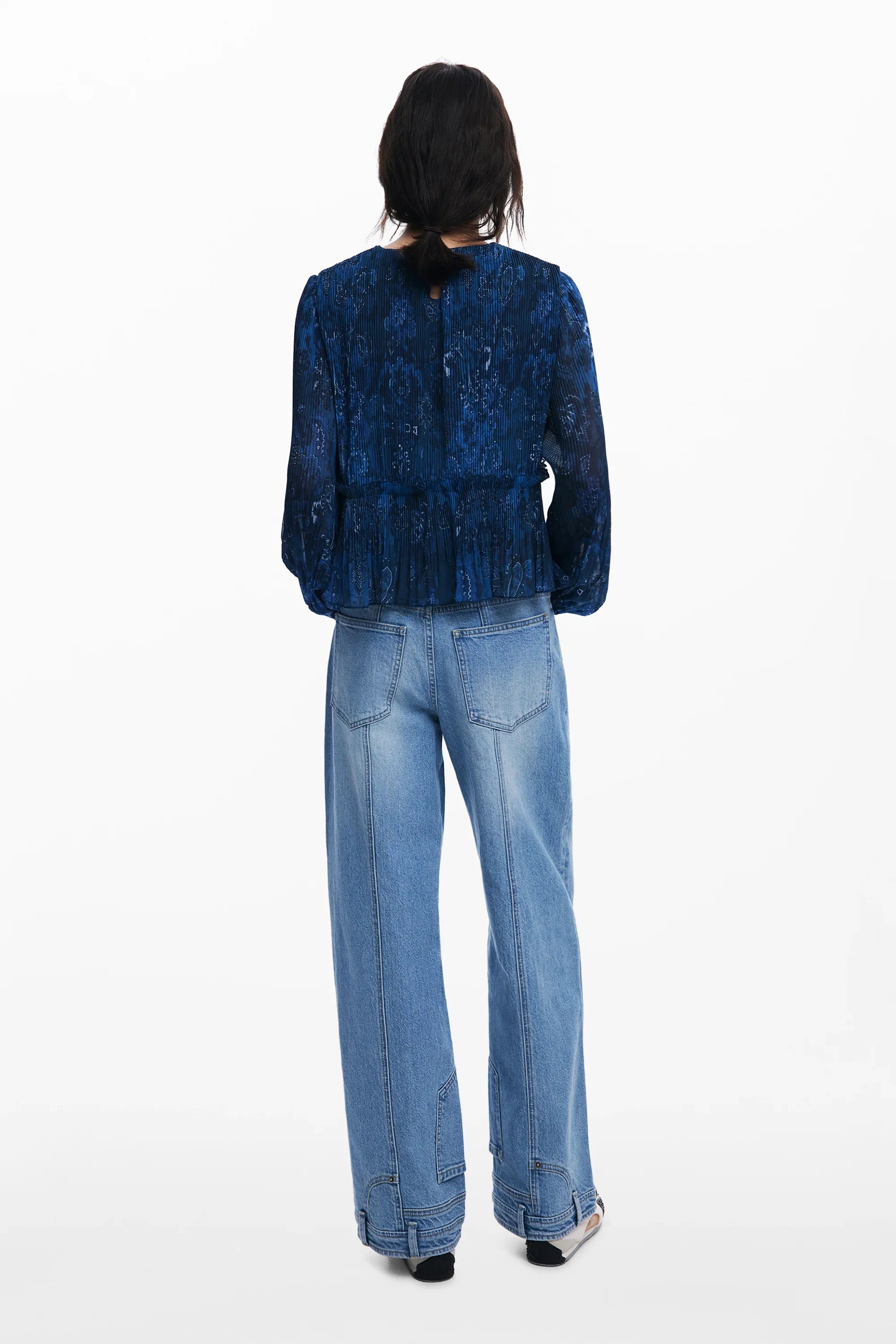 דוגמנית לובשת חולצה כחולה עם דוגמה ומכנסי ג'ינס רחבים, CHOZEN, צילום מאחור