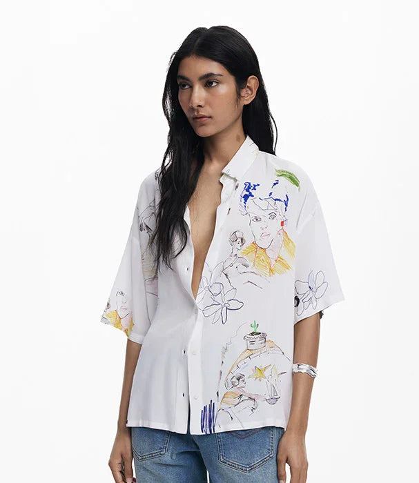 אישה לובשת חולצה לבנה עם הדפסים צבעוניים, אופנה ייחודית מקולקציית CHOZEN