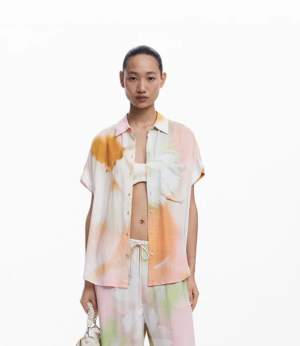 אישה לובשת חולצה ומכנסיים עם דפס פרחוני צבעוני, אופנת נשים CHOZEN, רקע לבן