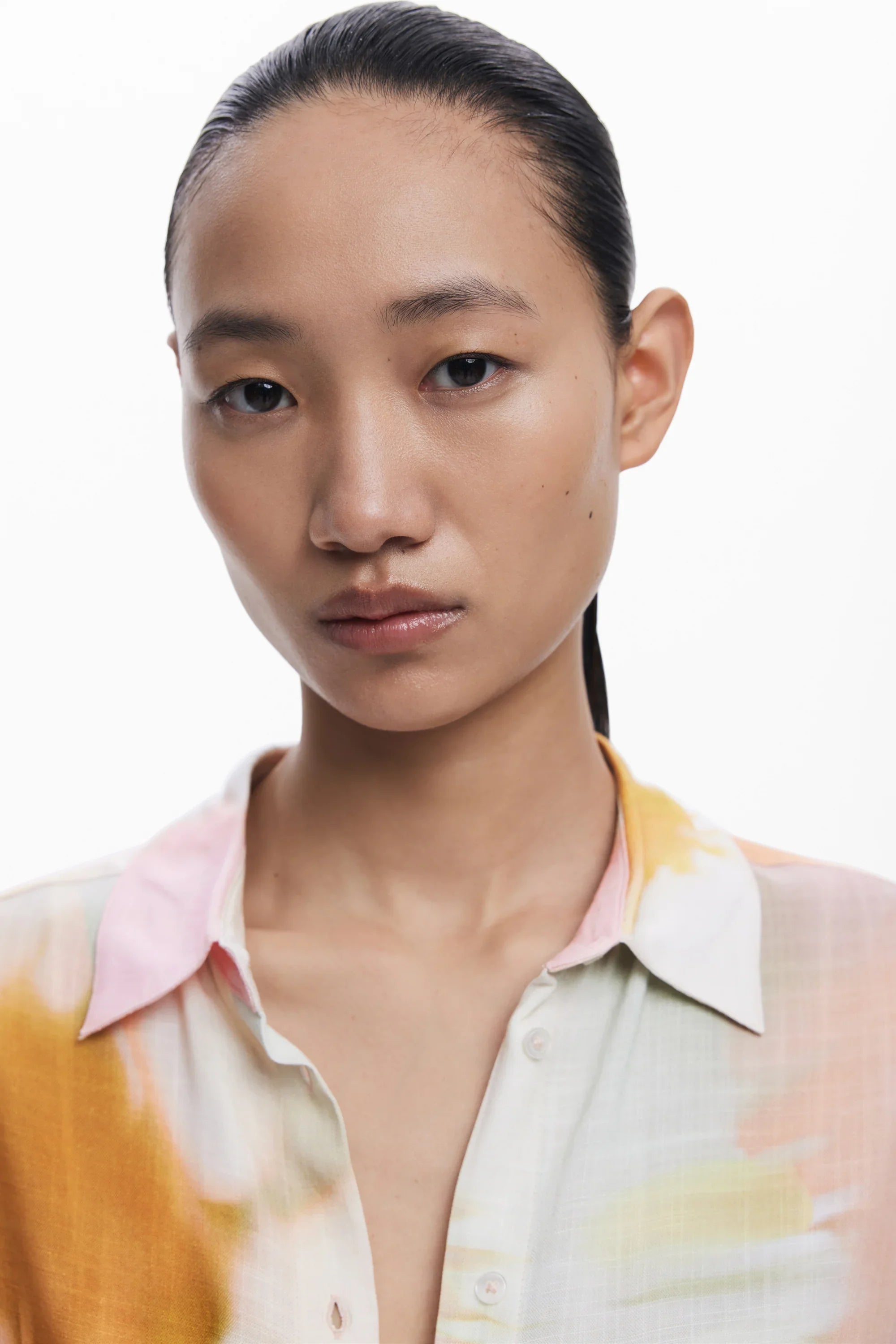 דוגמנית לובשת חולצה צבעונית עם דוגמת מים, צילום אופנה של CHOZEN על רקע לבן