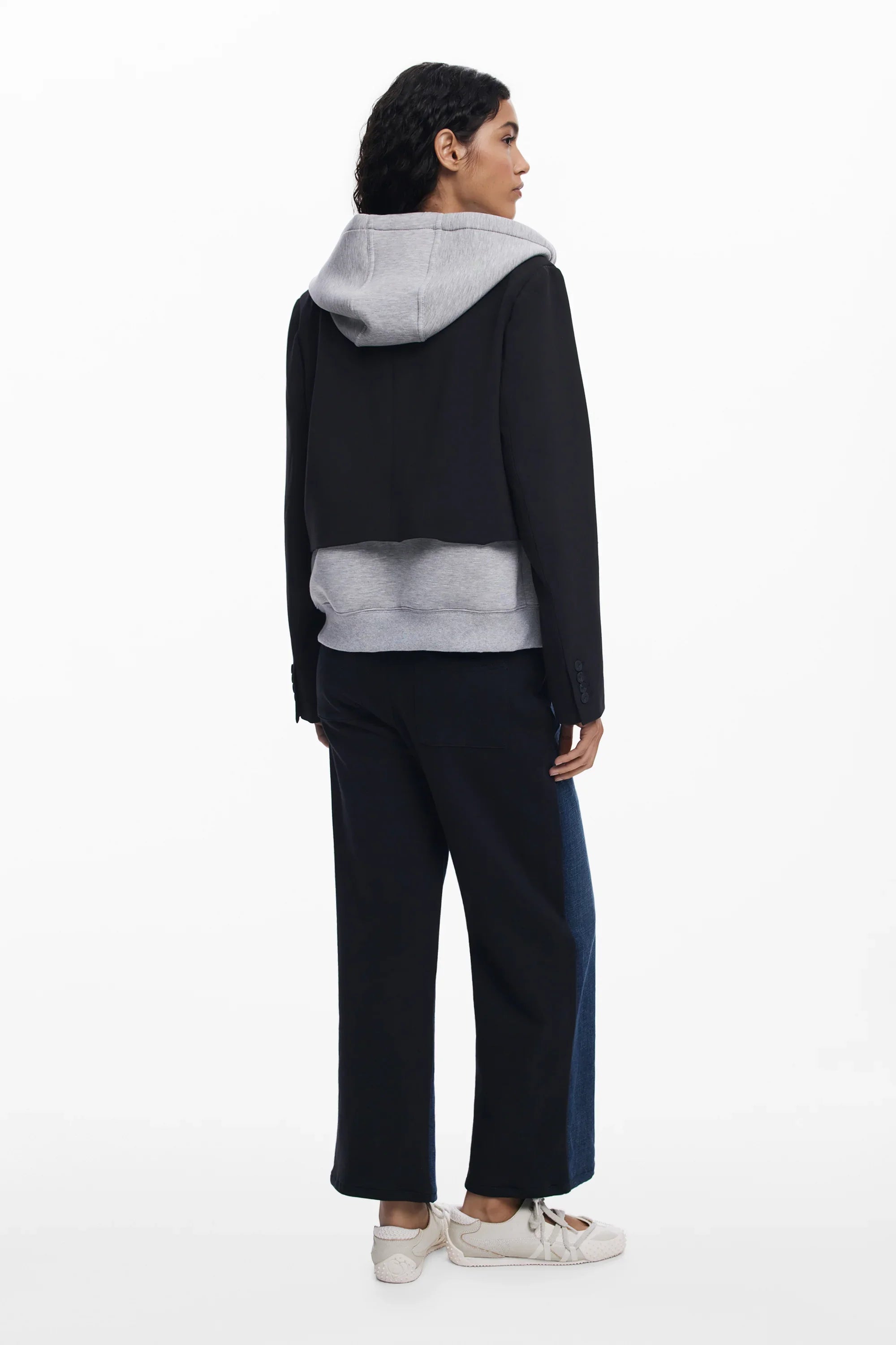 אישה עם קפוצ׳ון אפור, ז׳קט שחור קצר ומכנסיים רחבים, אופנת רחוב CHOZEN