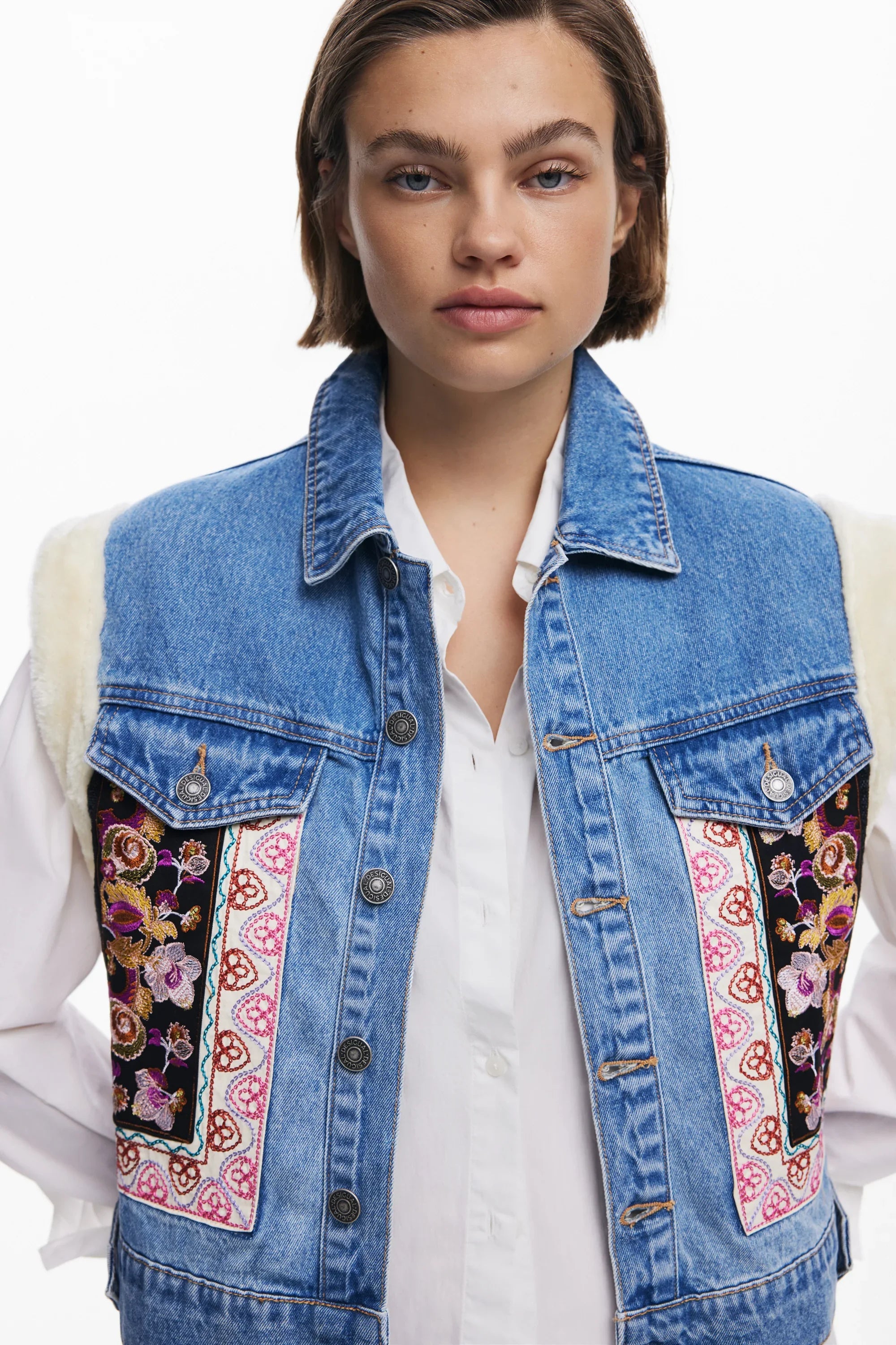 אישה לובשת וסט ג'ינס עם עיטורים צבעוניים רקומים, אופנת CHOZEN, צילום סטודיו