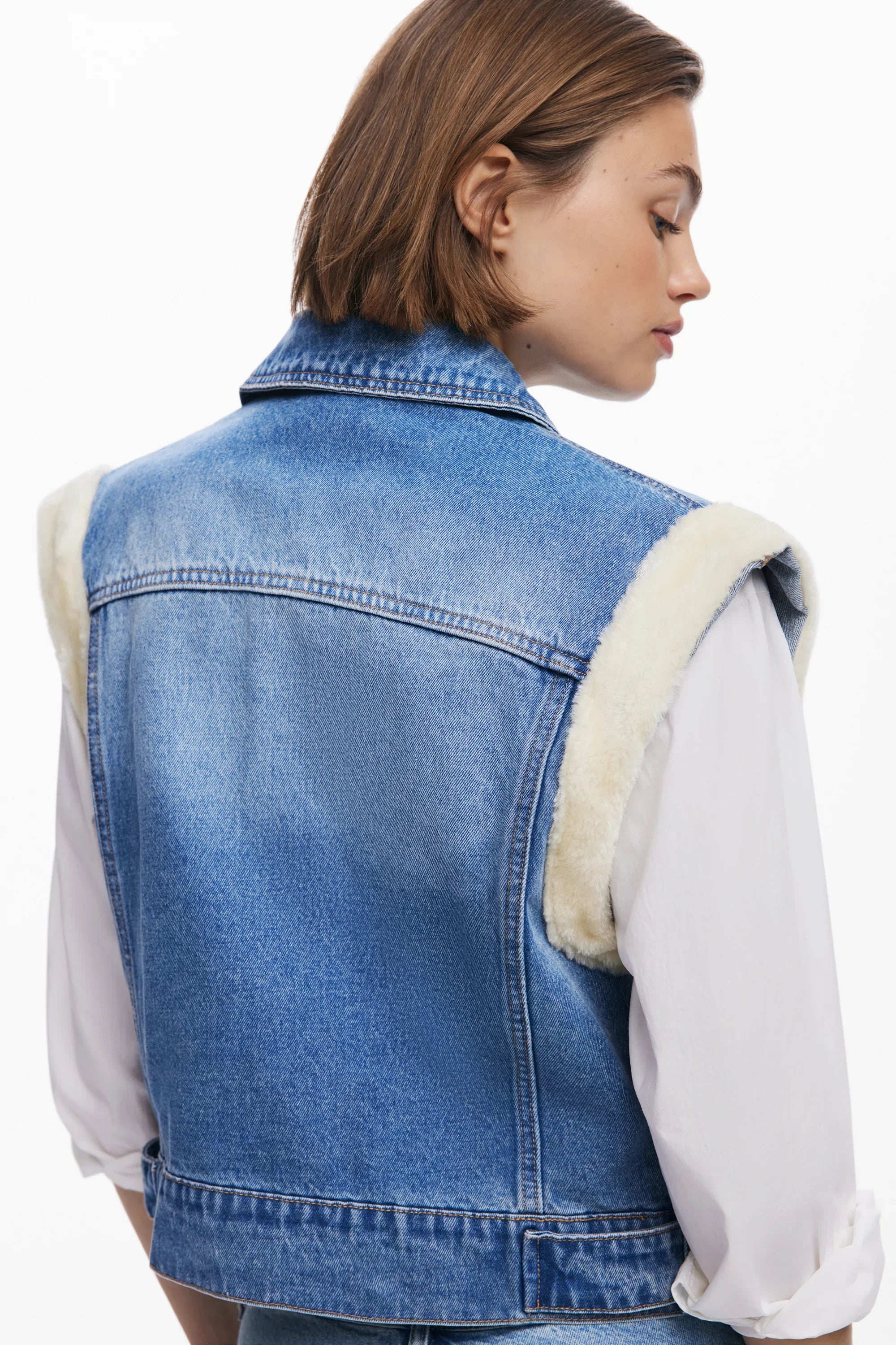 אישה לובשת וסט ג'ינס כחול עם פרווה בהשראת מותגים מובילים מבית CHOZEN