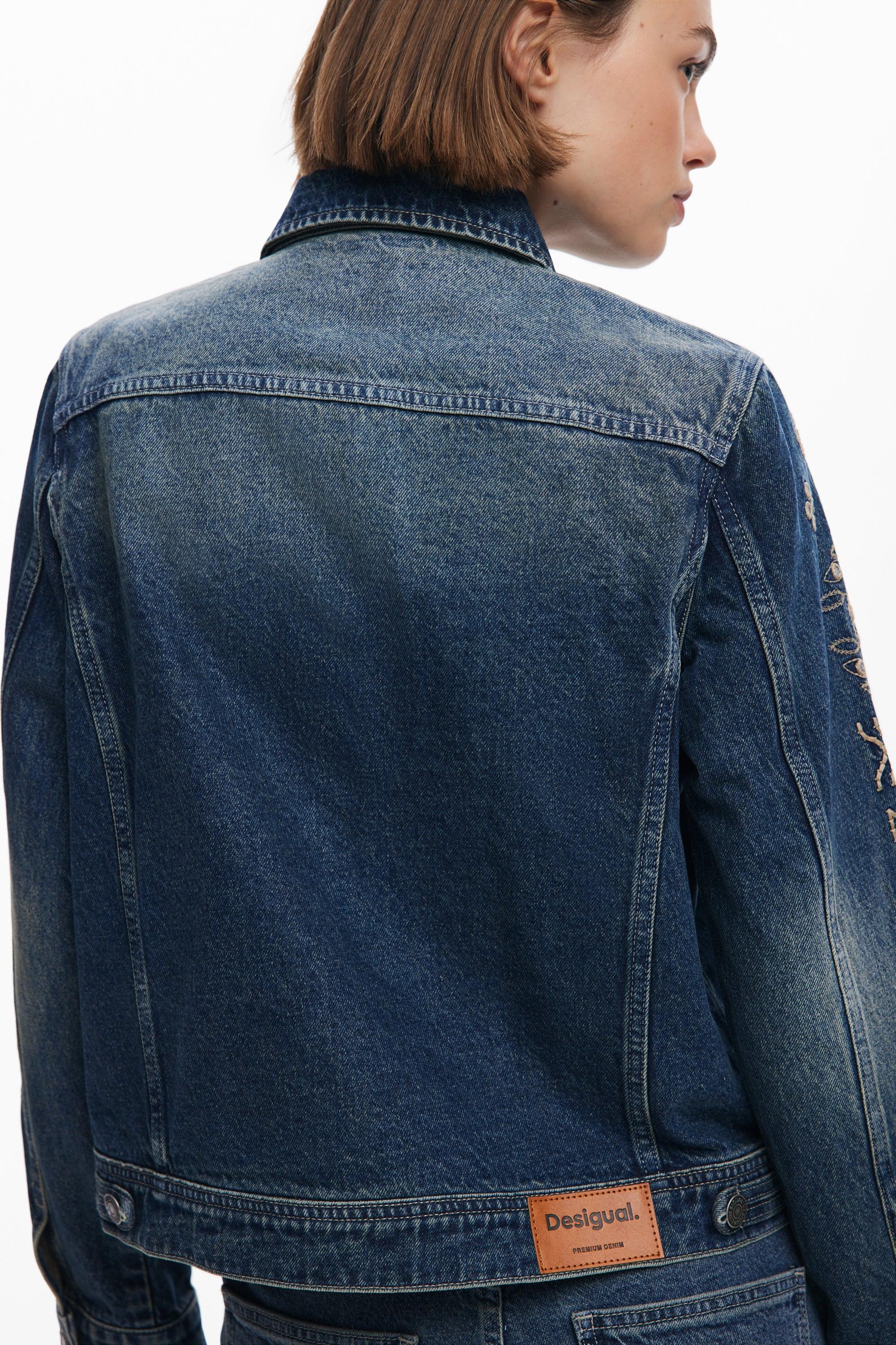 אישה לובשת ג'קט ג'ינס Desigual כחול, תווית המותג בולטת, אופנה עדכנית בקבוצת אלפא