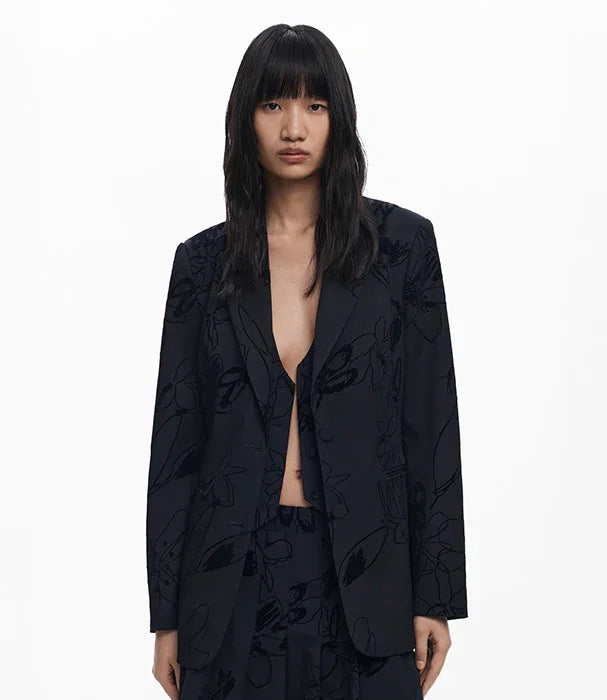 דוגמנית לובשת בלייזר שחור עם דוגמת פרחים מבית CHOZEN, צילום סטודיו על רקע לבן