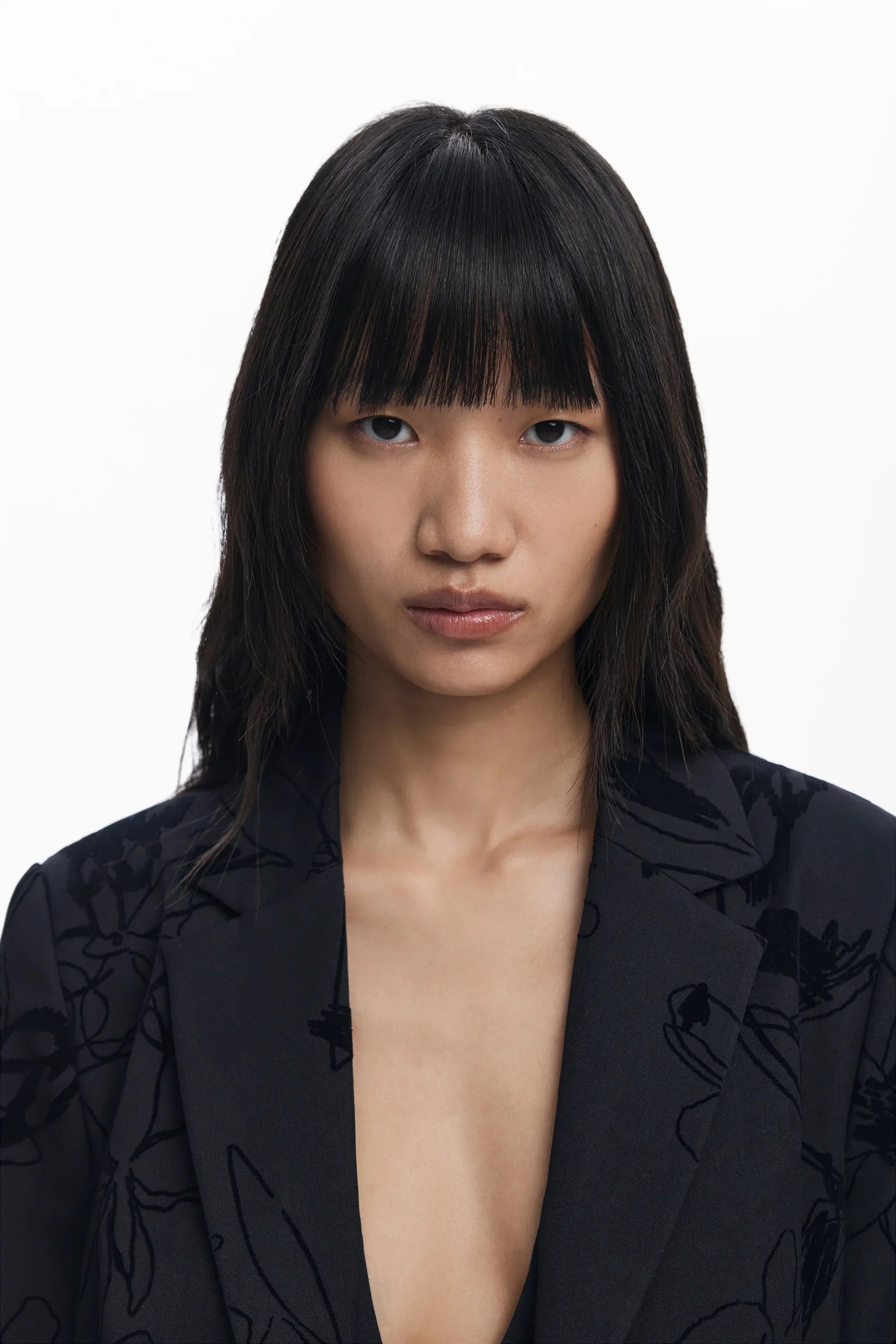 דוגמנית לובשת בלייזר שחור עם דוגמת פרחים, מצולמת באווירה נקייה, אופנה CHOZEN