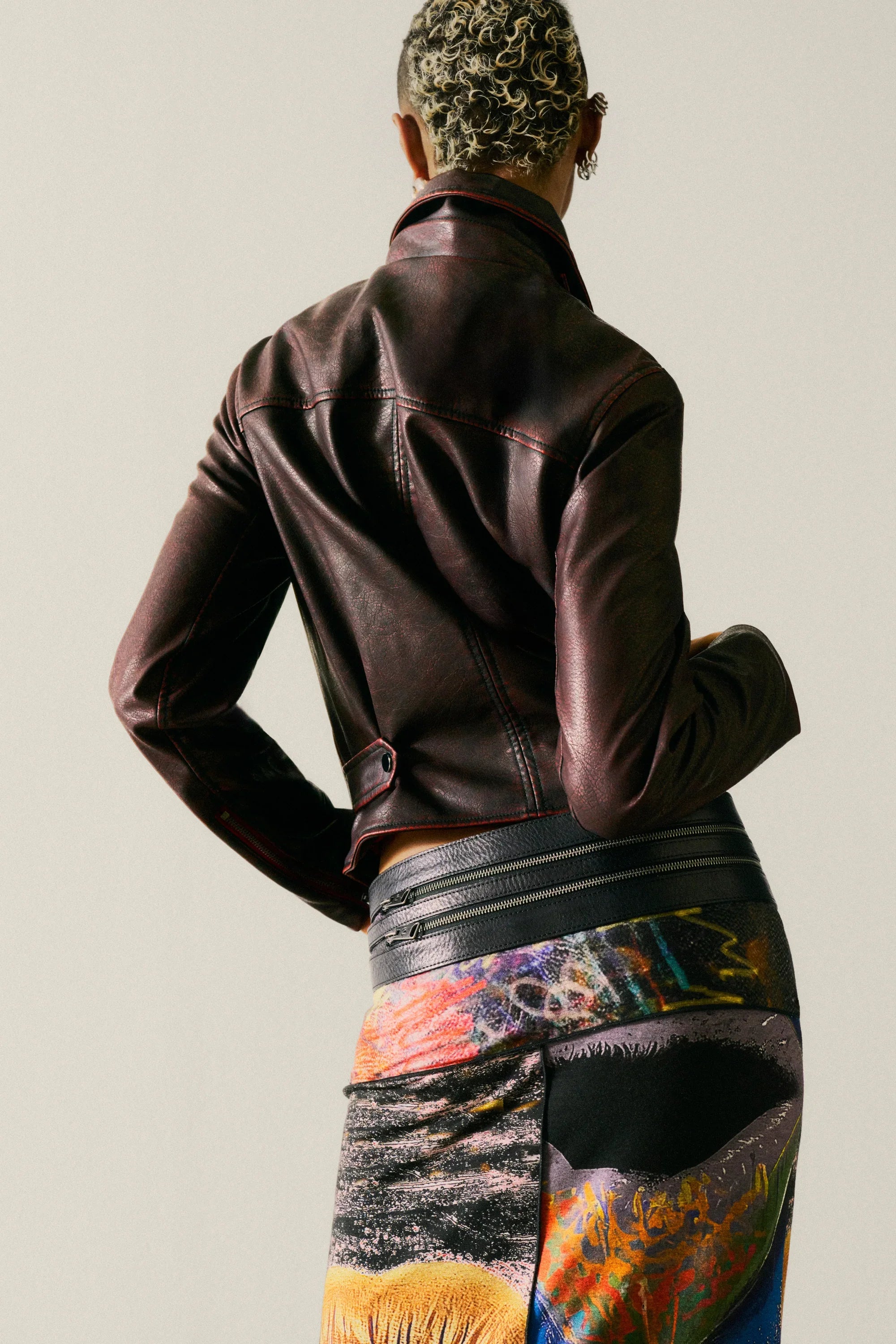 אישה עם ג'קט עור חום של CHOZEN וחצאית צבעונית עם הדפס אמנותי, אופנת יוקרה