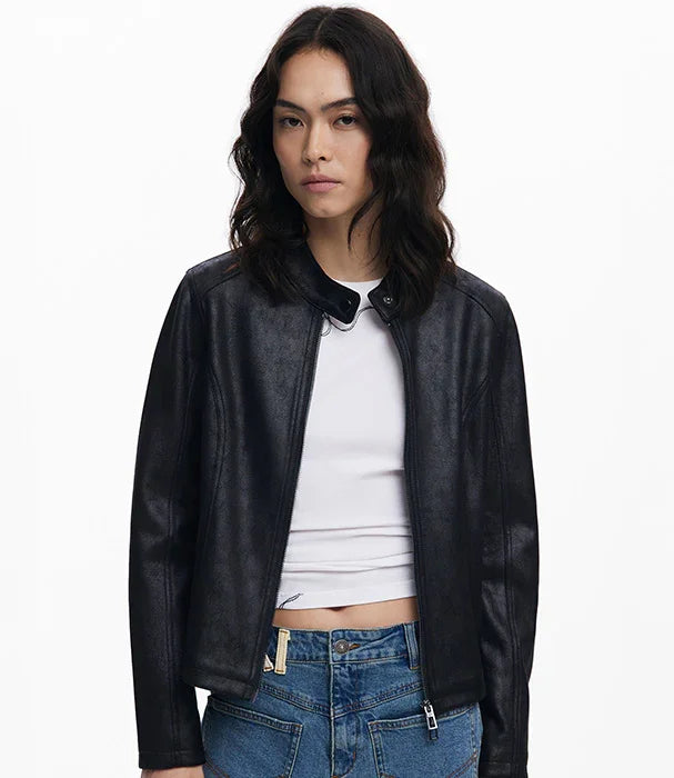 אישה לובשת ז'קט עור שחור אופנתי מעל חולצה לבנה ומכנסי ג'ינס, צילום ל-CHOZEN מותג אופנה