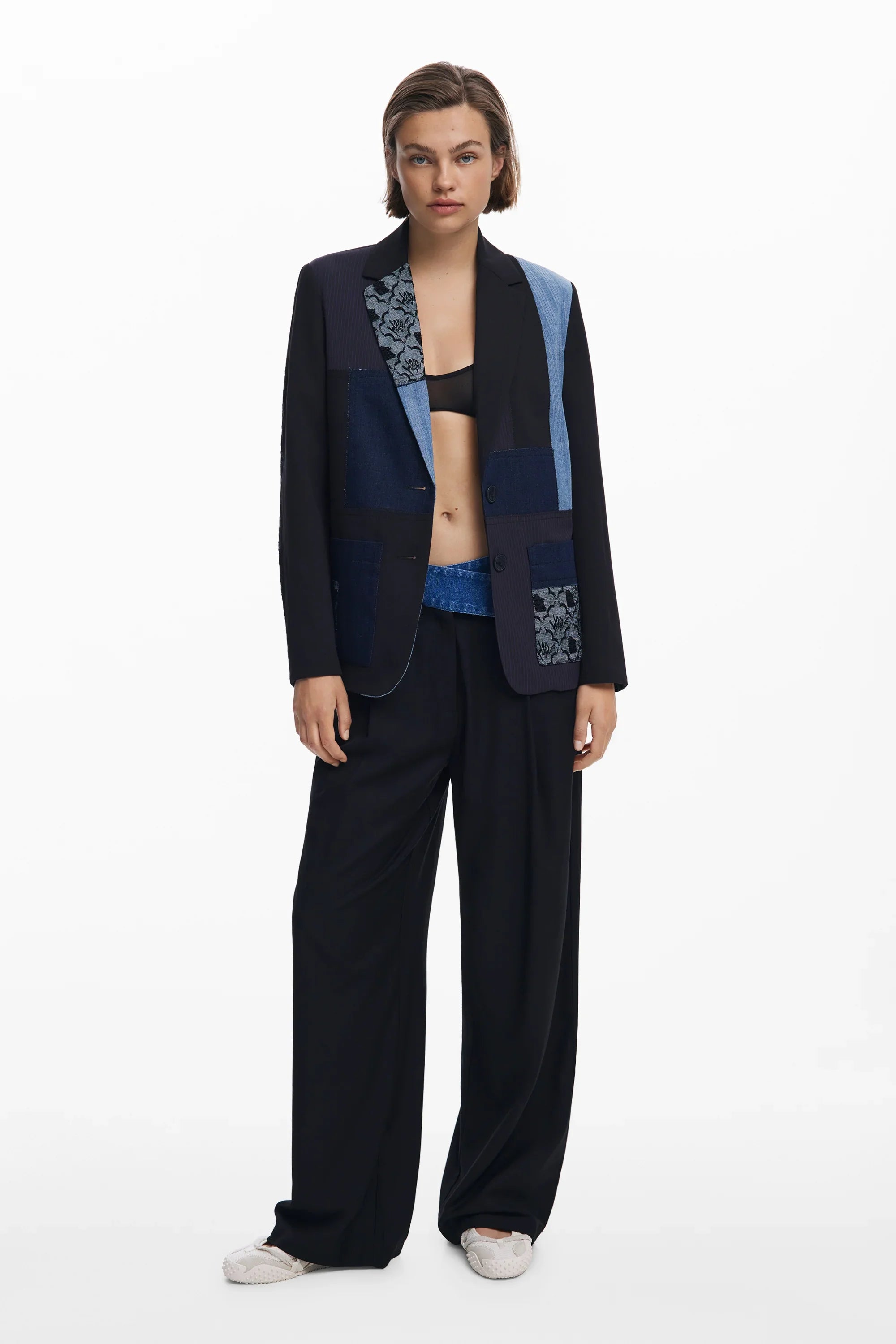 דוגמנית לובשת ז'קט פאטצ'ים כחול-שחור ומכנסיים רחבים, אופנת נשים CHOZEN