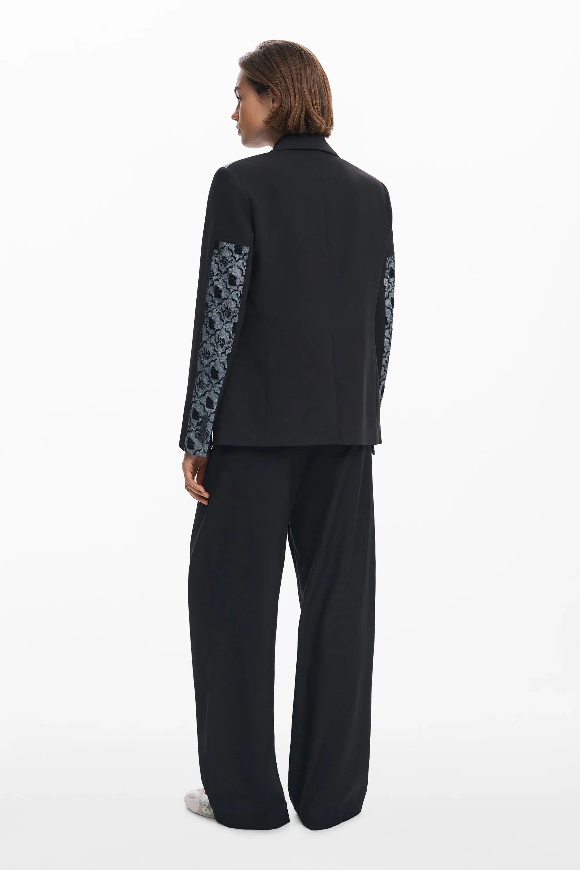 אישה לובשת חליפת שני חלקים שחורה עם שרוולים בדוגמת פרחים, אופנה יוקרתית CHOZEN