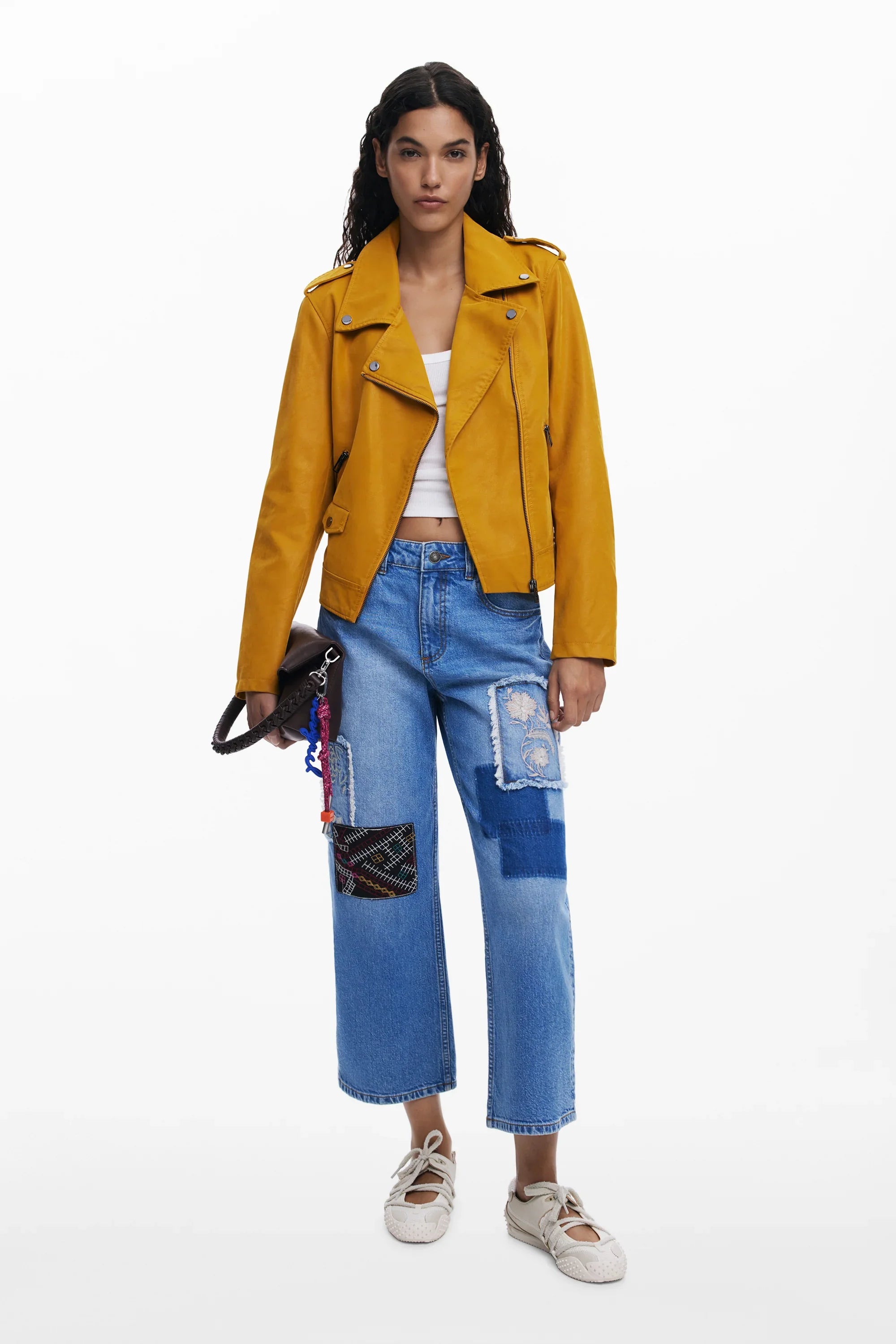 אשה עם ג'קט צהוב, טופ לבן ומכנסי ג'ינס עם טלאים, אופנה עדכנית CHOZEN