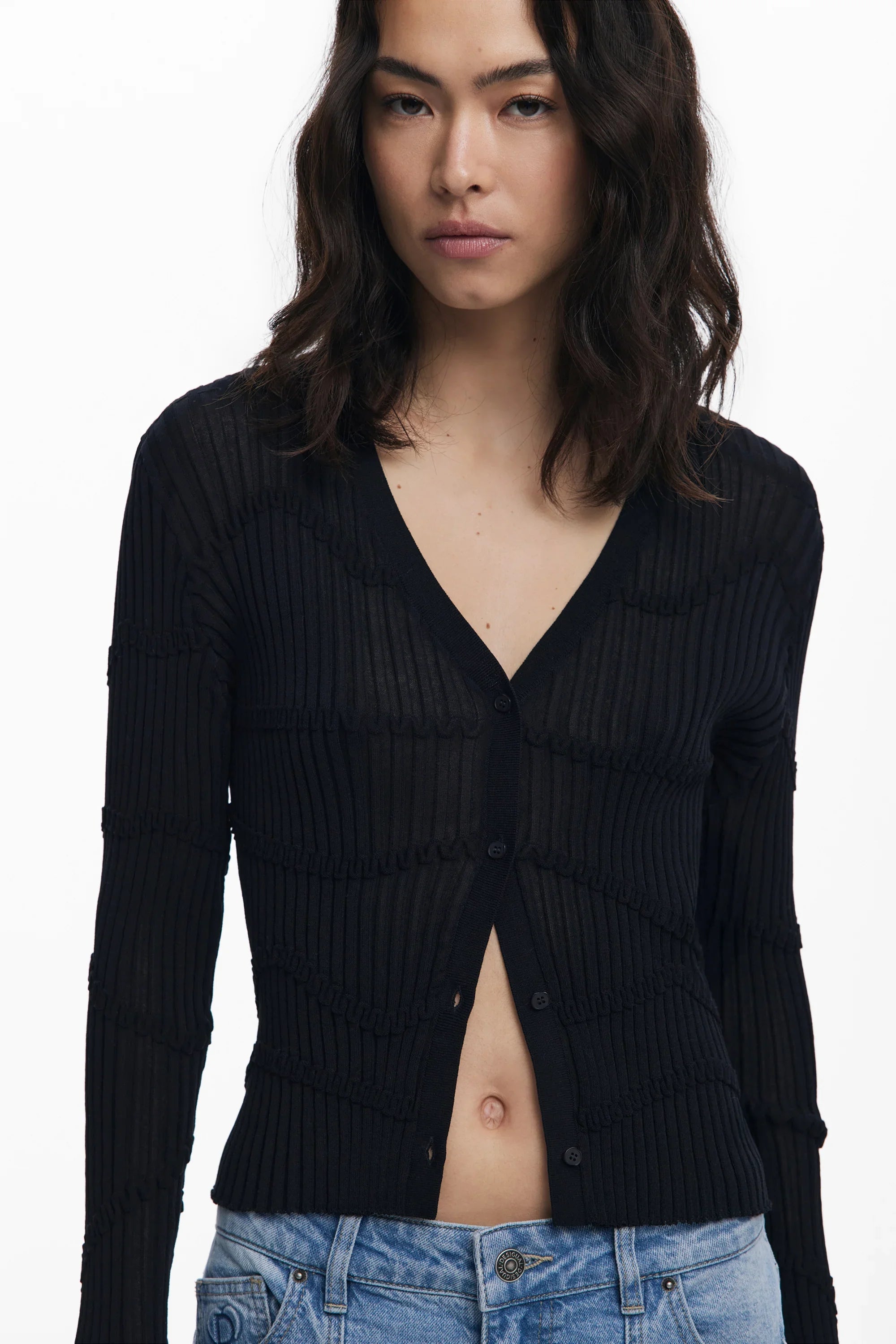 דוגמנית לובשת סריג שחור מכופתר עם שרוולים ארוכים ומכנסי ג'ינס כחול, CHOZEN בגדי אופנה