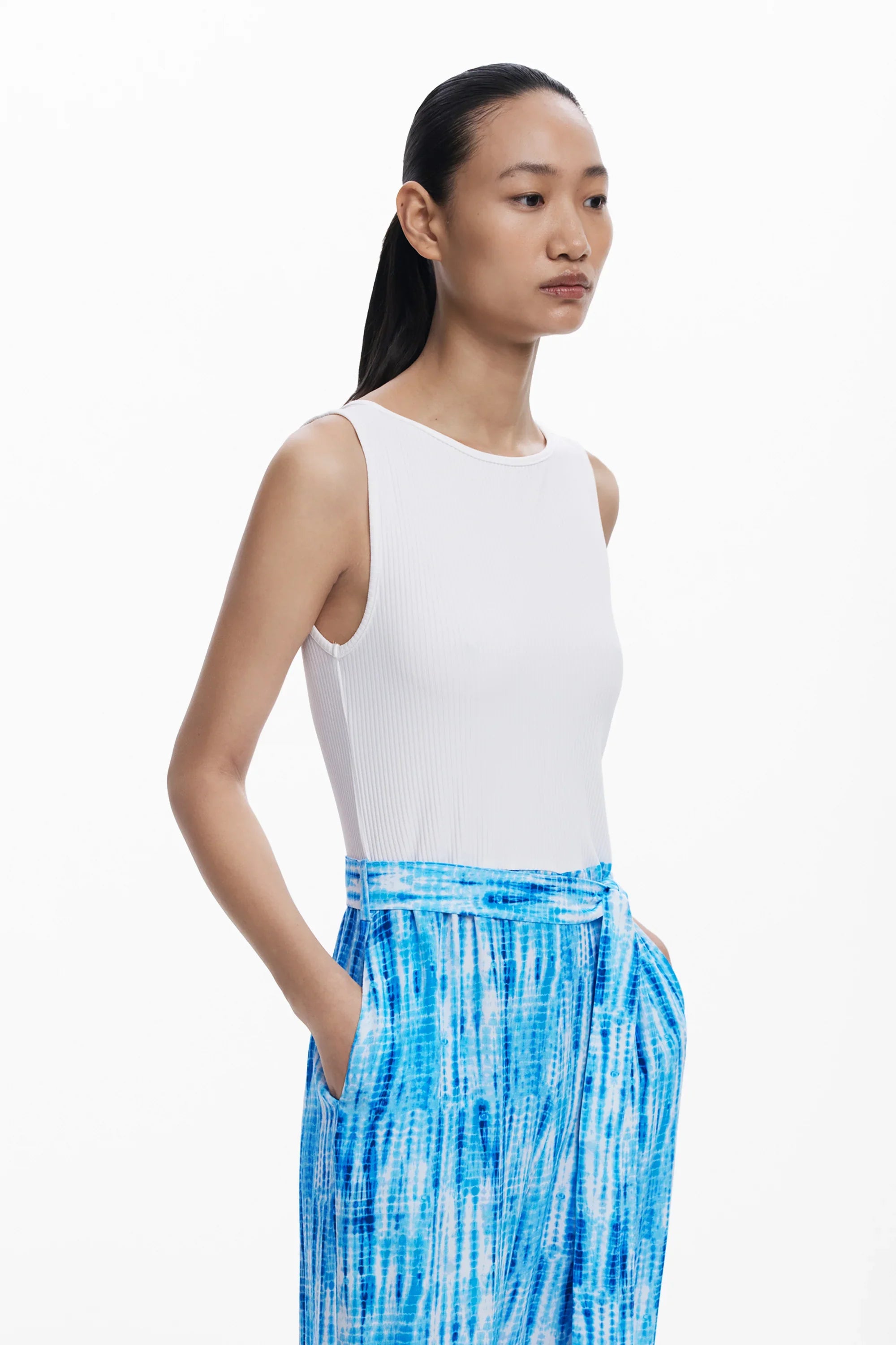 דוגמנית לובשת גופיה לבנה ומכנסי טאי-דאי כחולים, אופנה עדכנית CHOZEN