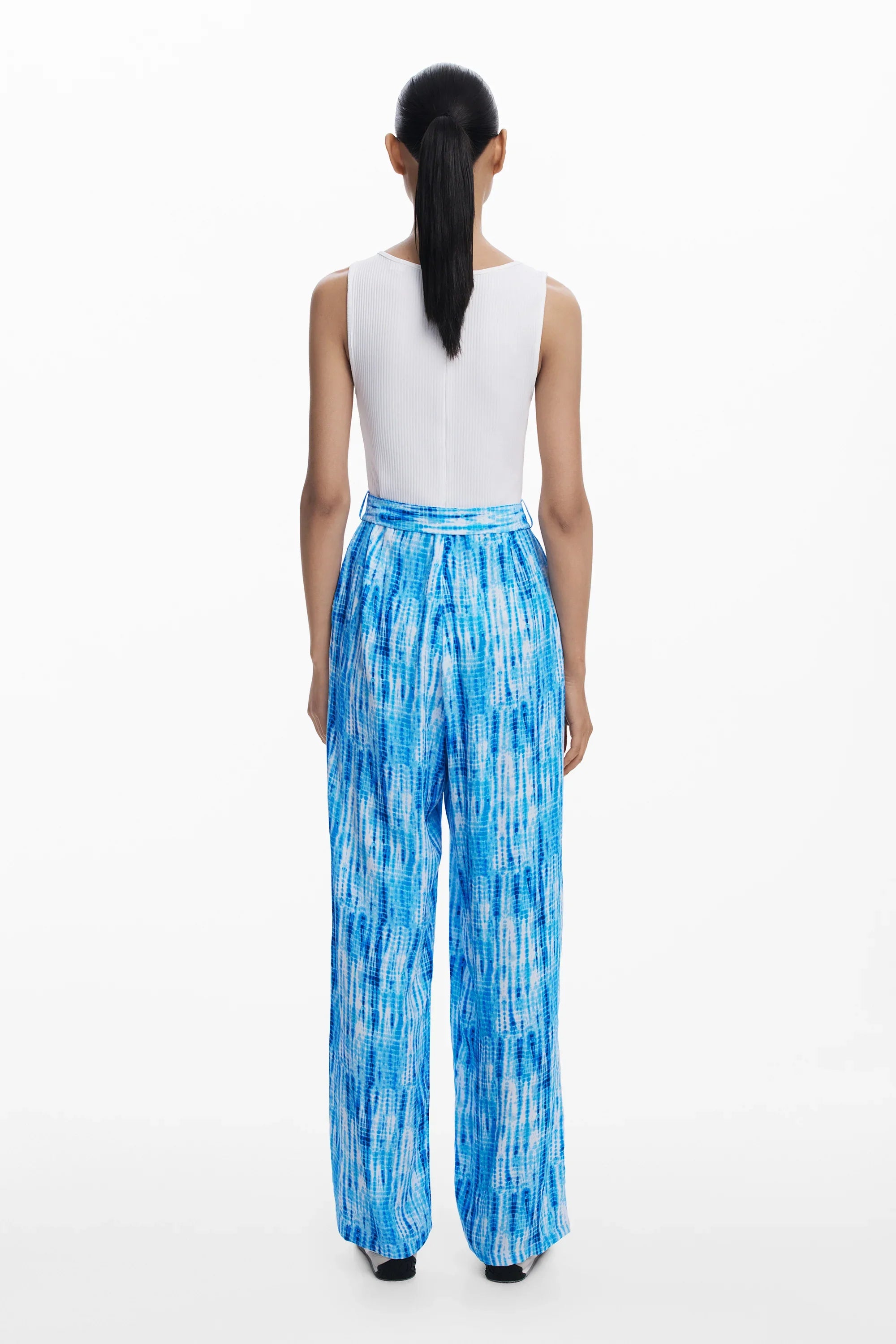 דוגמנית לובשת גופיה לבנה ומכנסיים כחולים מודפסים, אופנת נשים CHOZEN