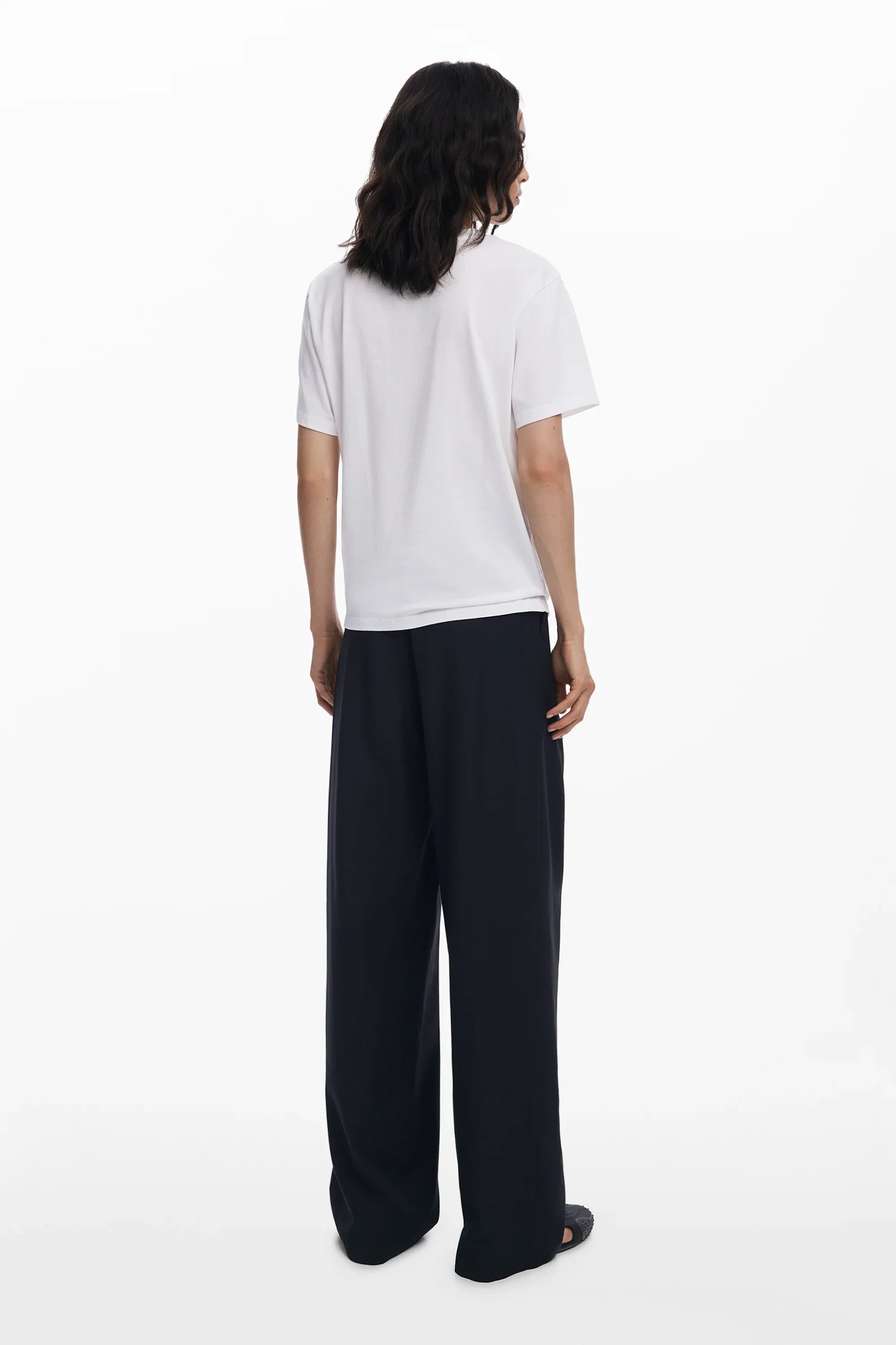 אישה בחולצת טי שירט לבנה ומכנסיים שחורים רחבים, אופנה מודרנית CHOZEN