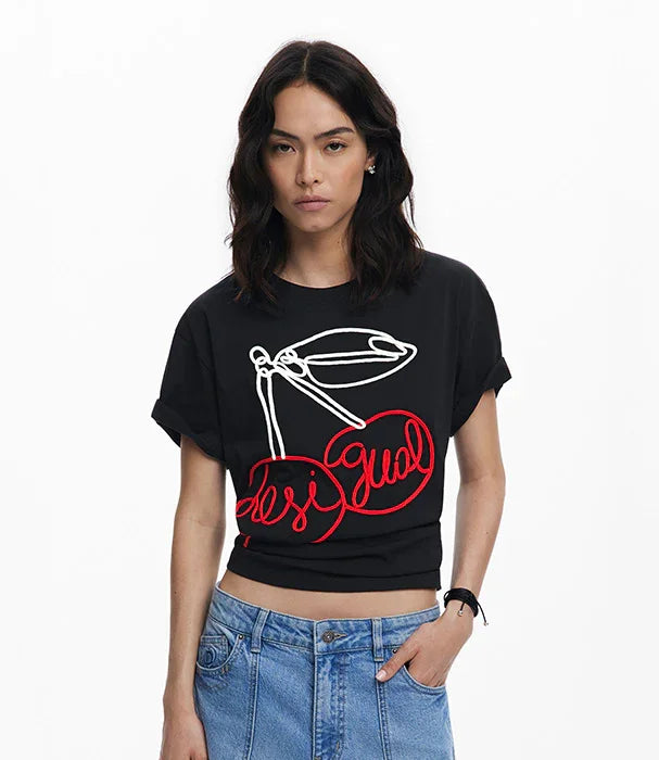 אישה עם חולצת טי שחורה של Desigual עם הדפס דובדבנים באדום ולבן, אופנה יוקרתית ב-CHOZEN