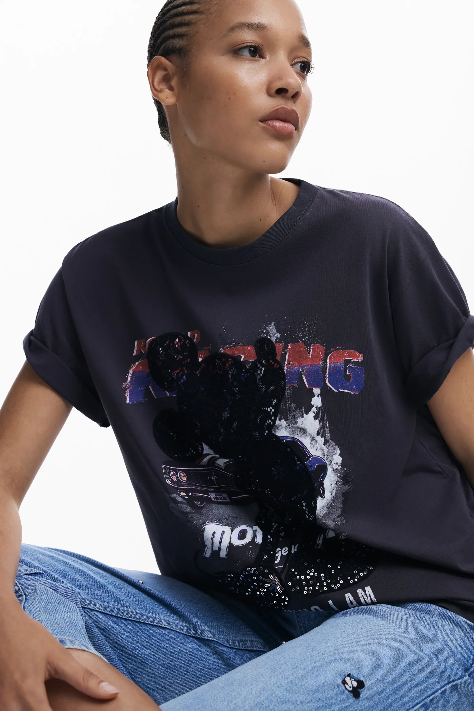 אשה לובשת חולצת טי כהה עם הדפס רכב וטקסט, ג'ינס, מותג CHOZEN בגדי אופנה