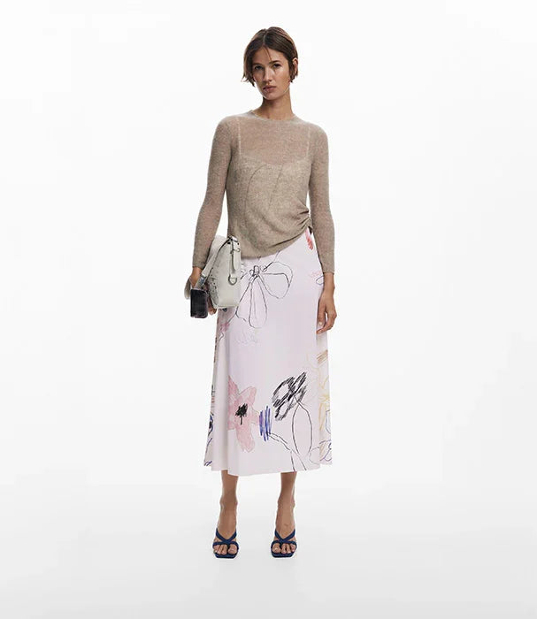 אישה עם סוודר בז' וחצאית פרחונית, תיק אפור ונעליים כחולות, אופנה בוטיק CHOZEN