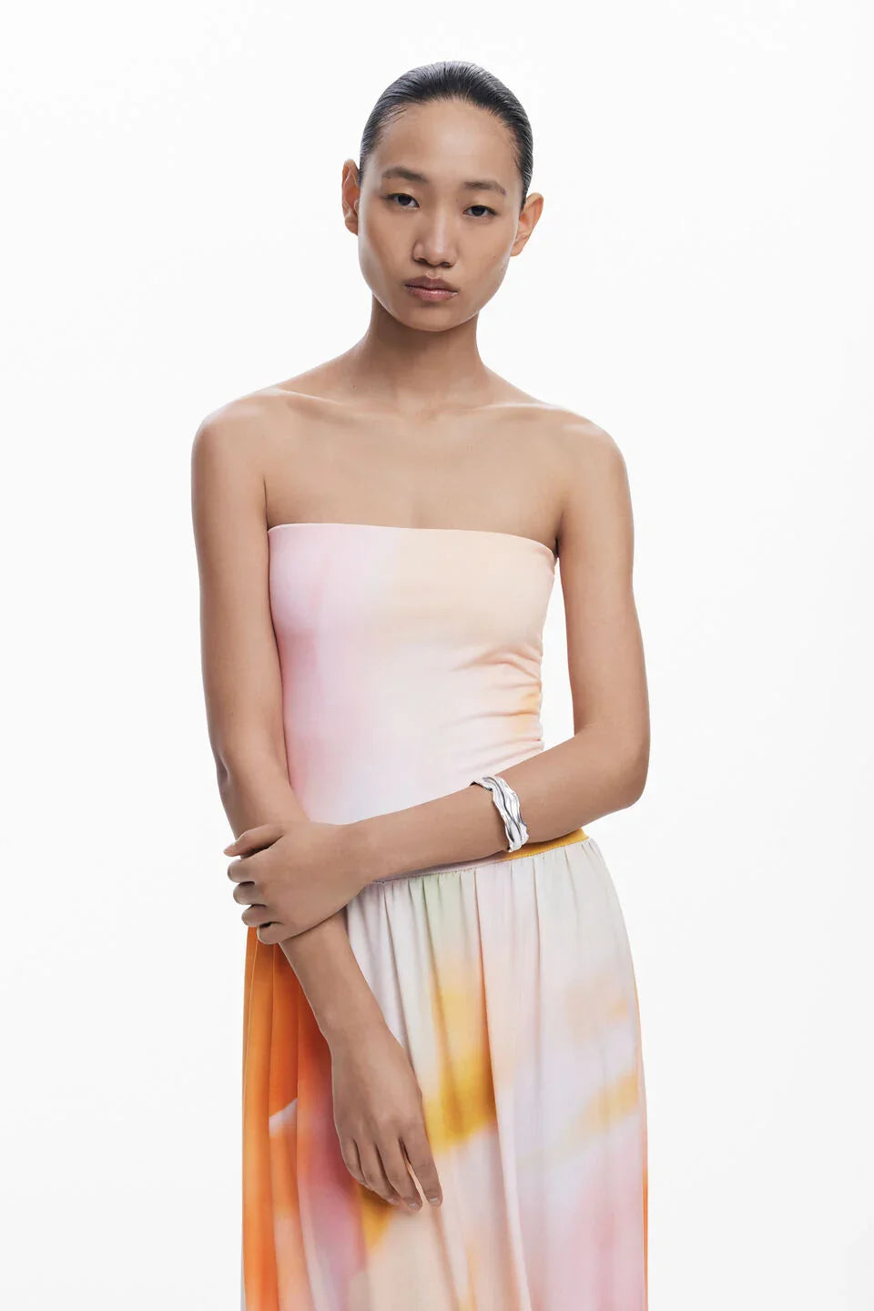 אישה מדגמנת שמלת סטרפלס צבעי פסטל אופנתית של CHOZEN, רקע לבן נקי