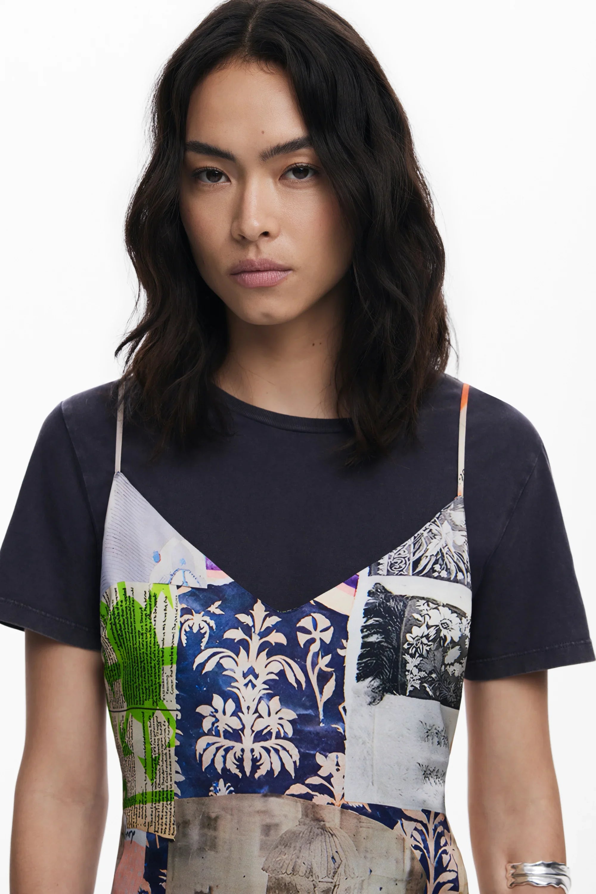 אישה עם שיער כהה בגלים לובשת חולצה שחורה עם שמלת פאטצ'ים צבעונית, אופנה CHOZEN