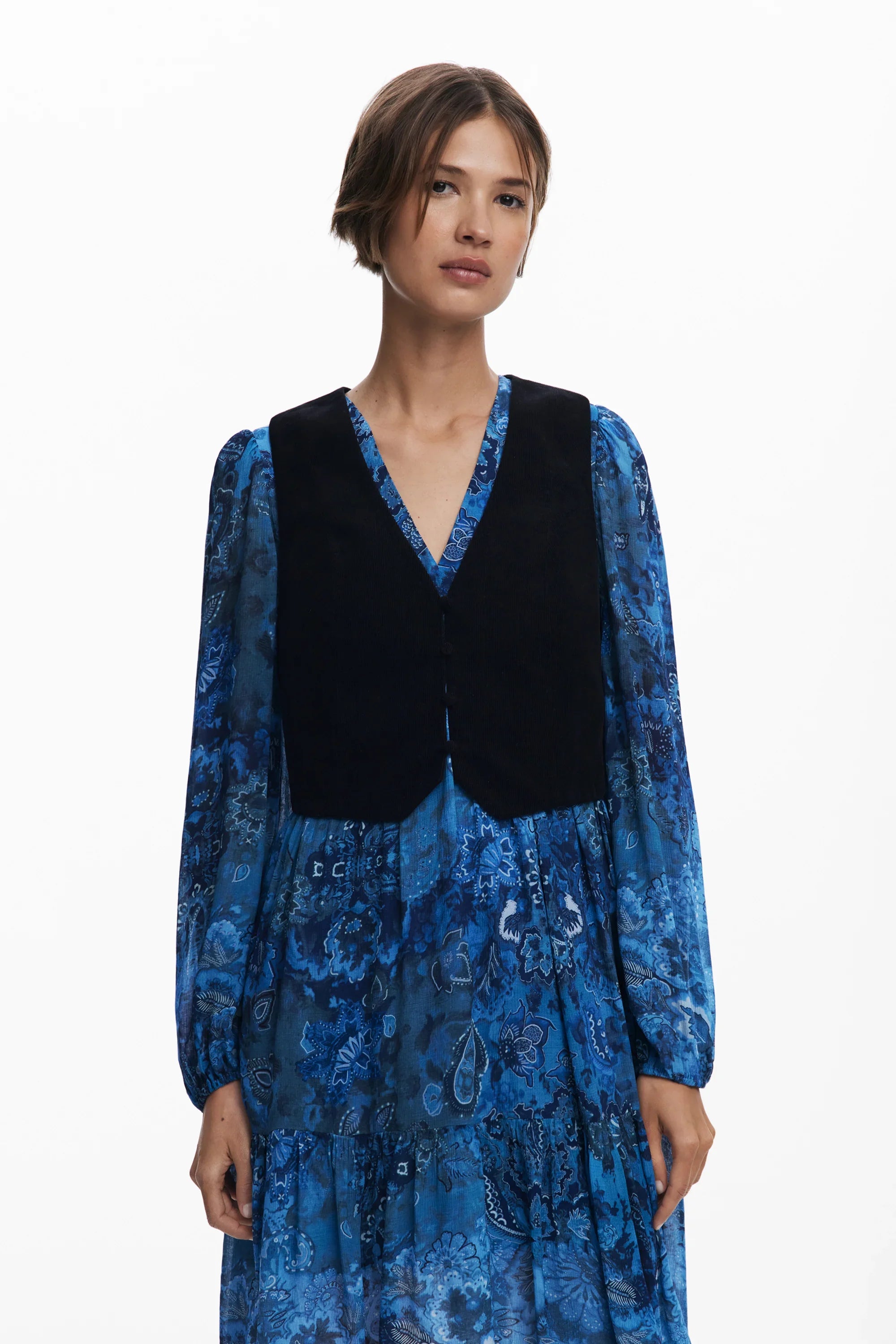 אישה עם שמלה כחולה פרחונית ואפוד שחור, אופנת נשים CHOZEN מבית קבוצת אלפא