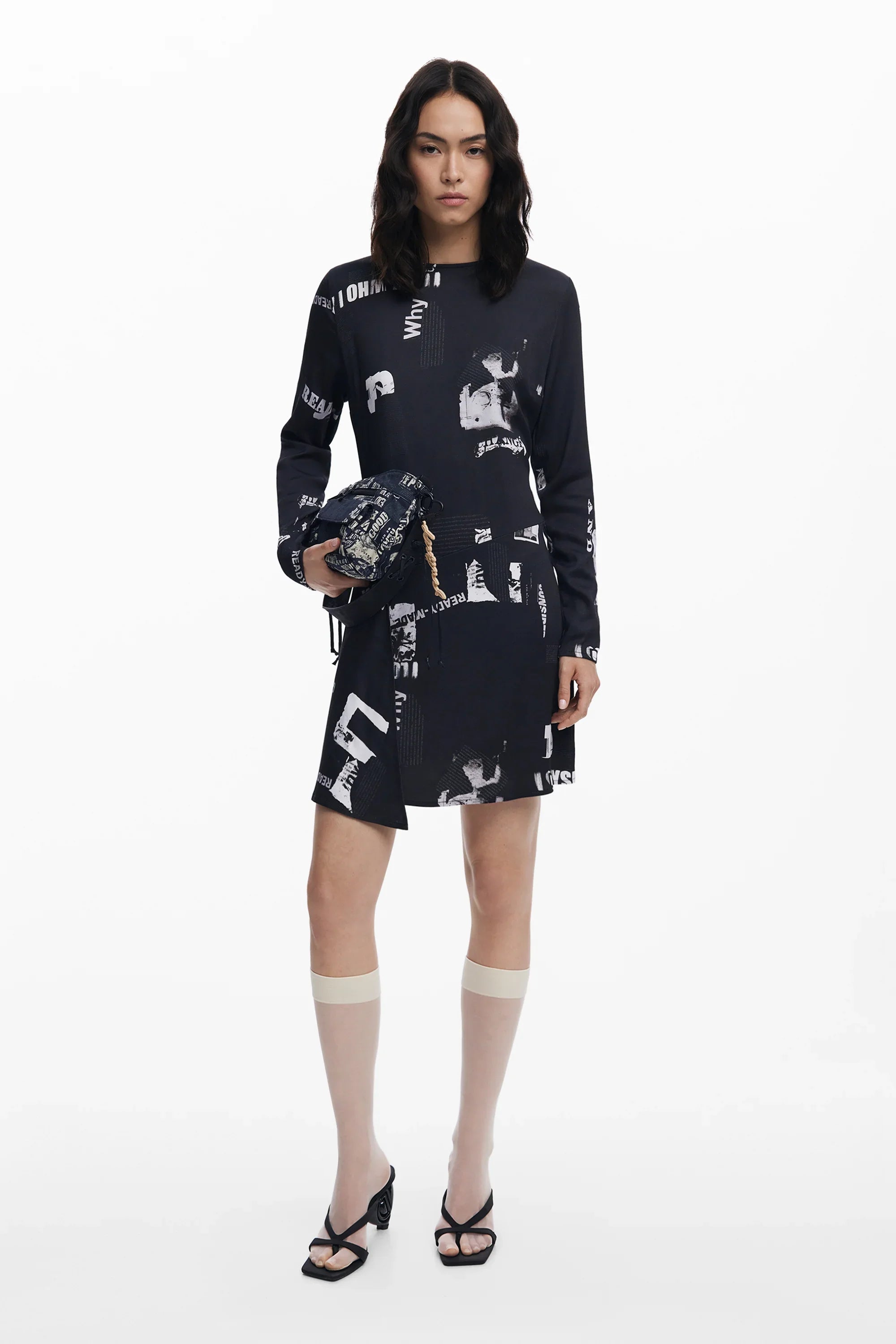 אישה עם שמלת מיני שחורה בעיצוב גראפי, מחזיקה תיק תואם, אופנה עדכנית CHOZEN