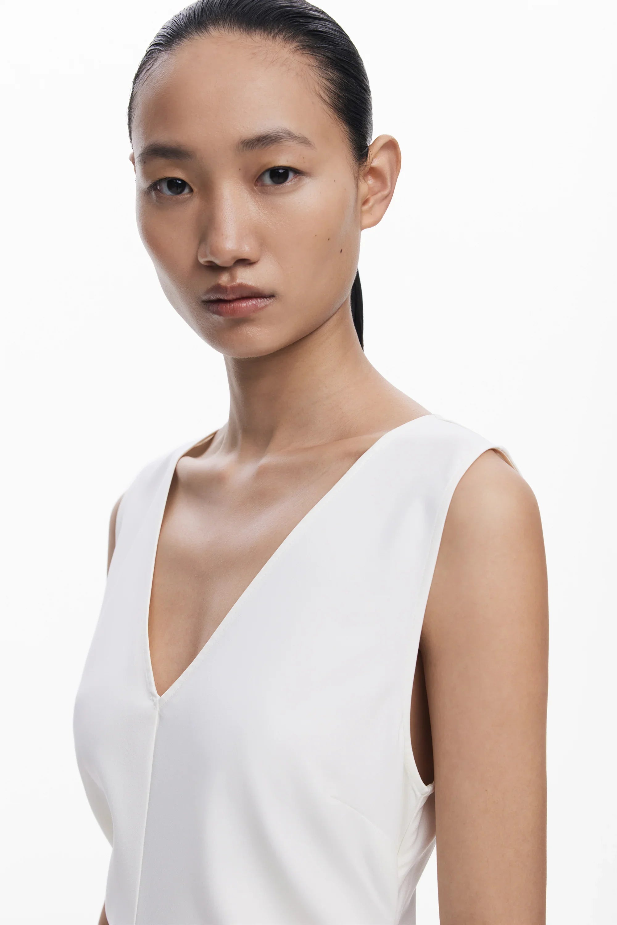 דוגמנית עם שיער אסוף לובשת שמלת וי לבנה, צילום אופנה מינימליסטי, CHOZEN